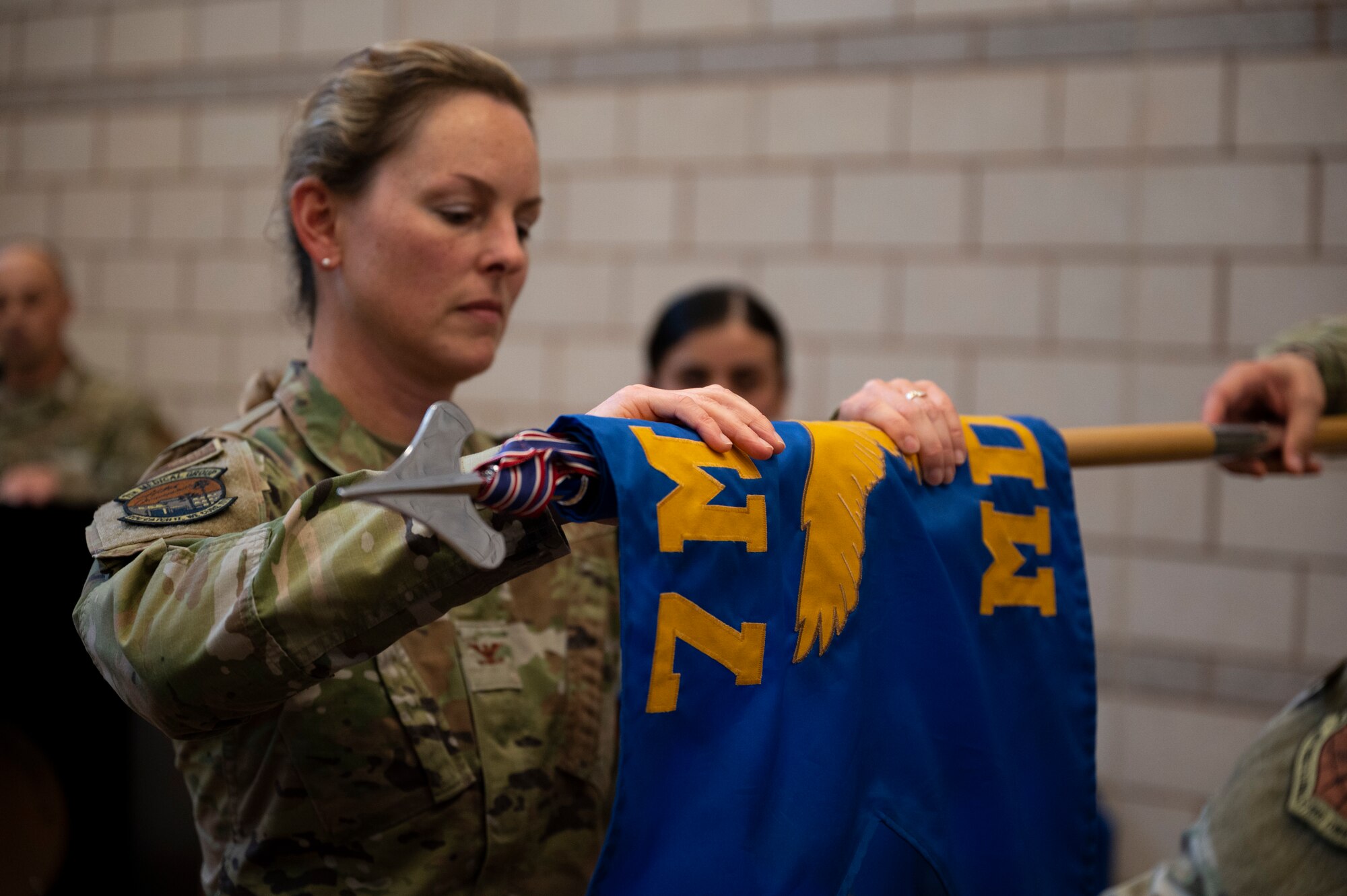 Col. Elizabeth Somsel, 7th Medical Group commander, cases the colors of the 7th Medical Support Squadron during the 7th MDSS Inactivation Ceremony on Dyess Air Force Base, Texas, June 24, 2022. The casing of the colors commemorates the accomplishments of unit members past and present during inactivation. (U.S. Air Force photo by Senior Airman Reilly McGuire)