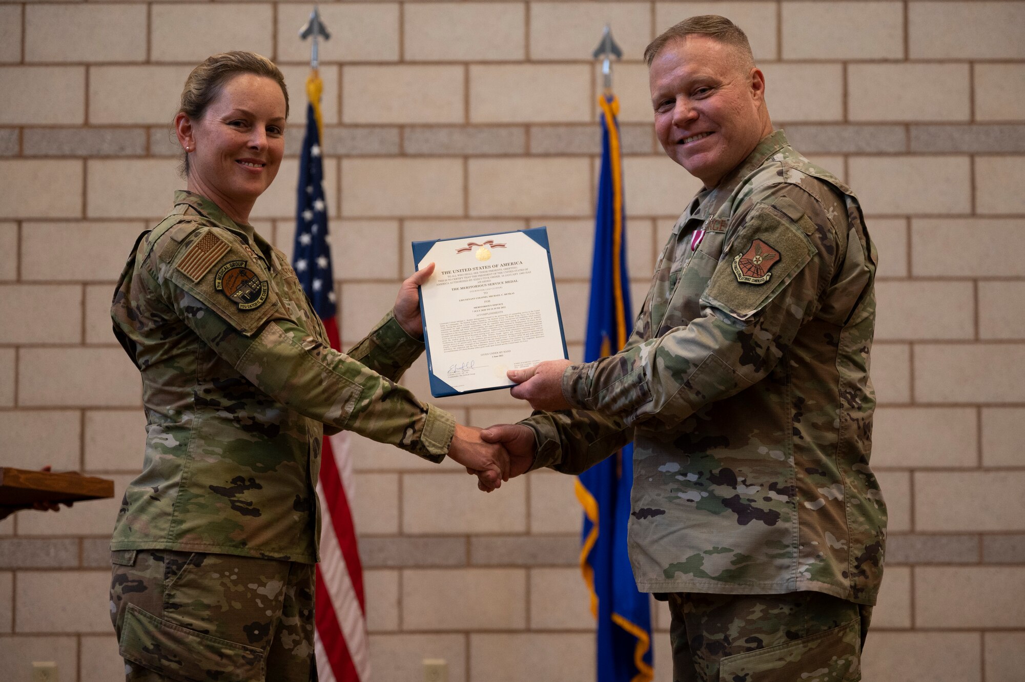 Col. Elizabeth Somsel, 7th Medical Group commander, presents the Meritorious Service Medal to Lt. Col. Michael Renkas, 7th Medical Support Squadron commander, during the 7th MDSS Inactivation Ceremony at Dyess Air Force Base, Texas, June 24, 2022. The Meritorious Service Medal is a military award presented to members of the United States Armed Forces who distinguished themselves by outstanding meritorious achievement or service to the United States. (U.S. Air Force photo by Senior Airman Reilly McGuire)