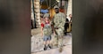 man in army uniform and boy wearing army gear pose for a photo.