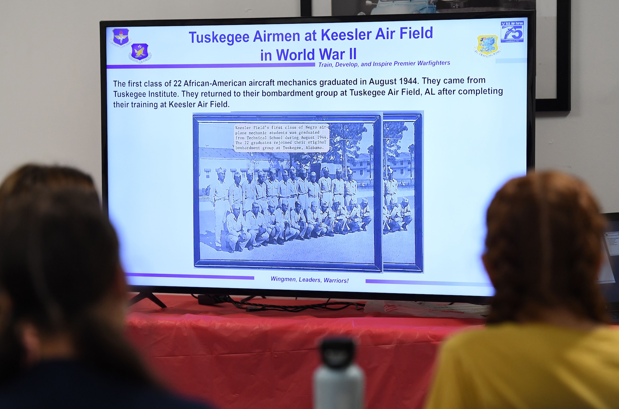 More than 15 school-aged children attend a briefing about the heritage of Keesler Air Force Base and the 81st Training Wing during a summer camp session inside the Mississippi Aviation Heritage Museum, Gulfport, Mississippi, June 27, 2022. Tyrone Scott, 81st TRW historian, delivered the briefing during the community outreach event. (U.S. Air Force photo by Kemberly Groue)
