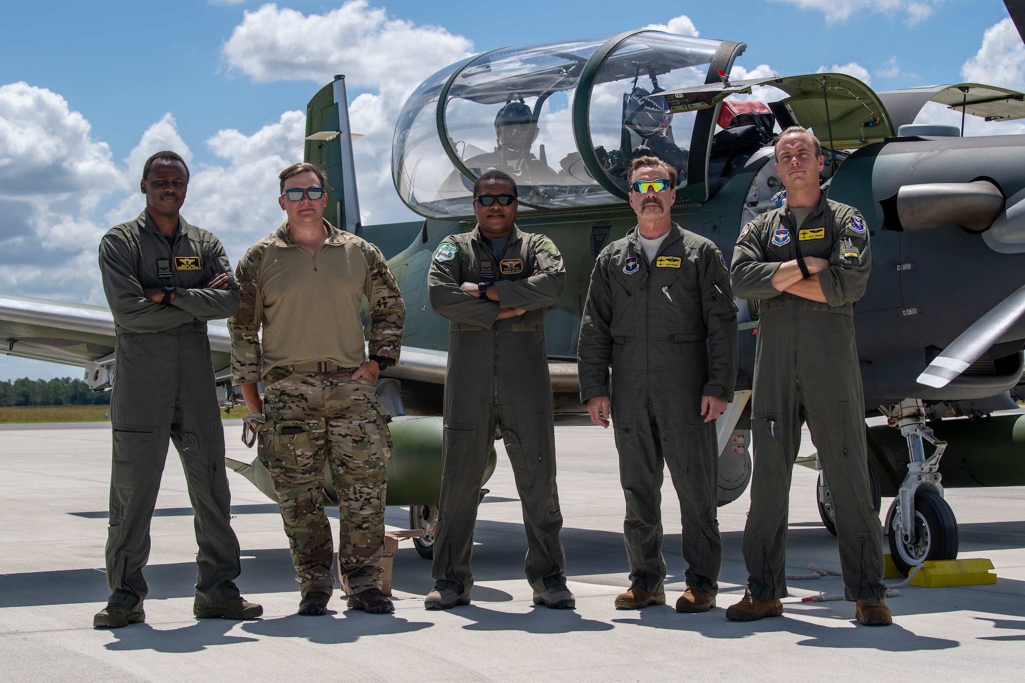 U.S. Air Force personnel and Colombian air force pilots pose for a picture in front of an AT-6E Wolverine at Avon Park Air Force Range, Florida, May 11, 2022. The U.S. Air Force partnered with Colombia, Tunisia, Nigeria, and Thailand to co-develop tactics, techniques and procedures to combat violent extremist organizations while demonstrating the capabilities of the Airborne Extensible Relay Over-Horizon Network. (U.S. Air Force photo by Airman 1st Class Deanna Muir)