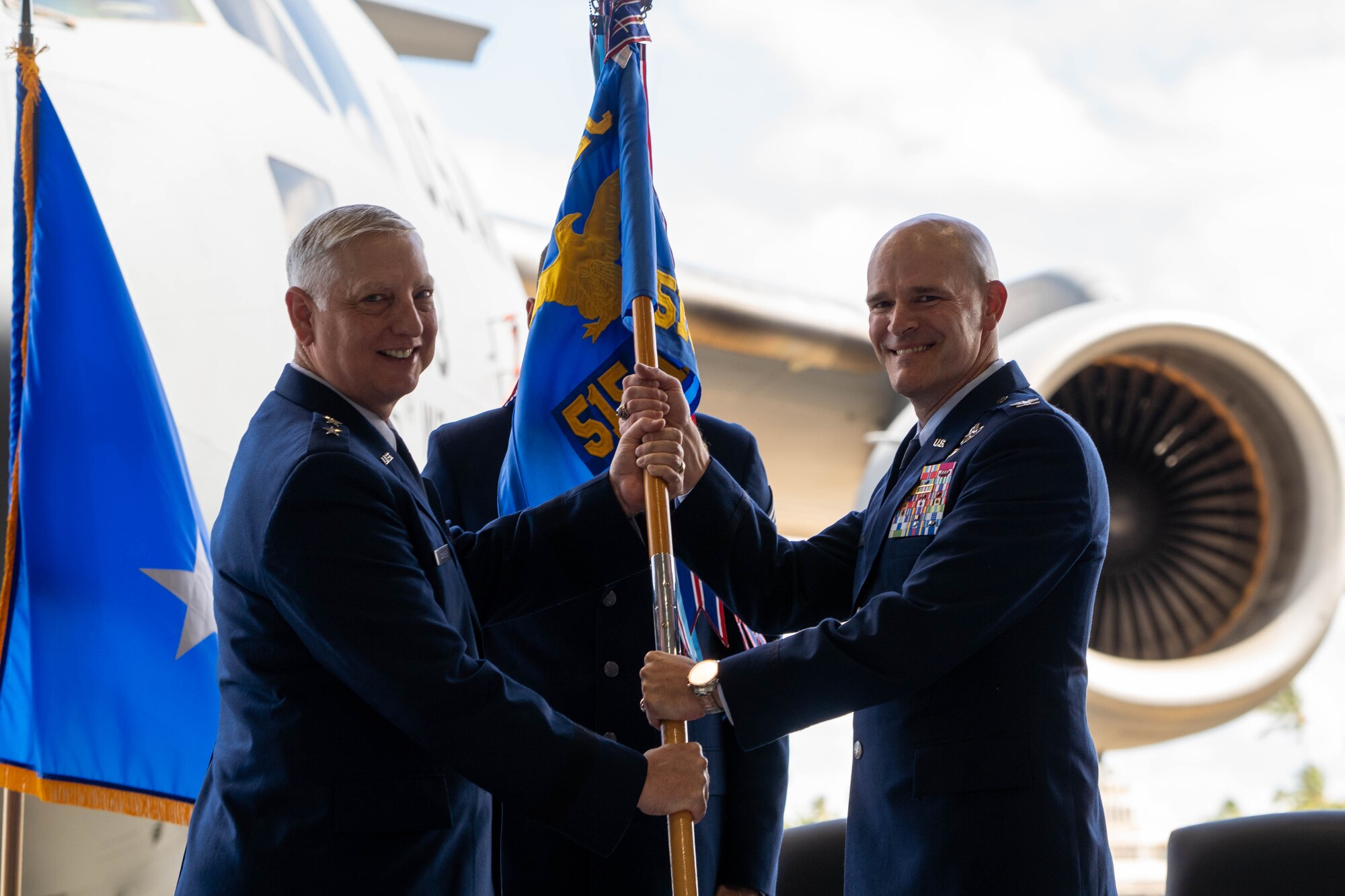 U.S. Air Force Maj. Gen. Mark D. Camerer, left, U.S. Air Force Expeditionary Center commander, passes the guidon to Col. Kyle A. Benwitz, 515th Air Mobility Operations Wing commander, as a symbol of Benwitz assuming command during the wing's June 28, 2022 change of command ceremony.