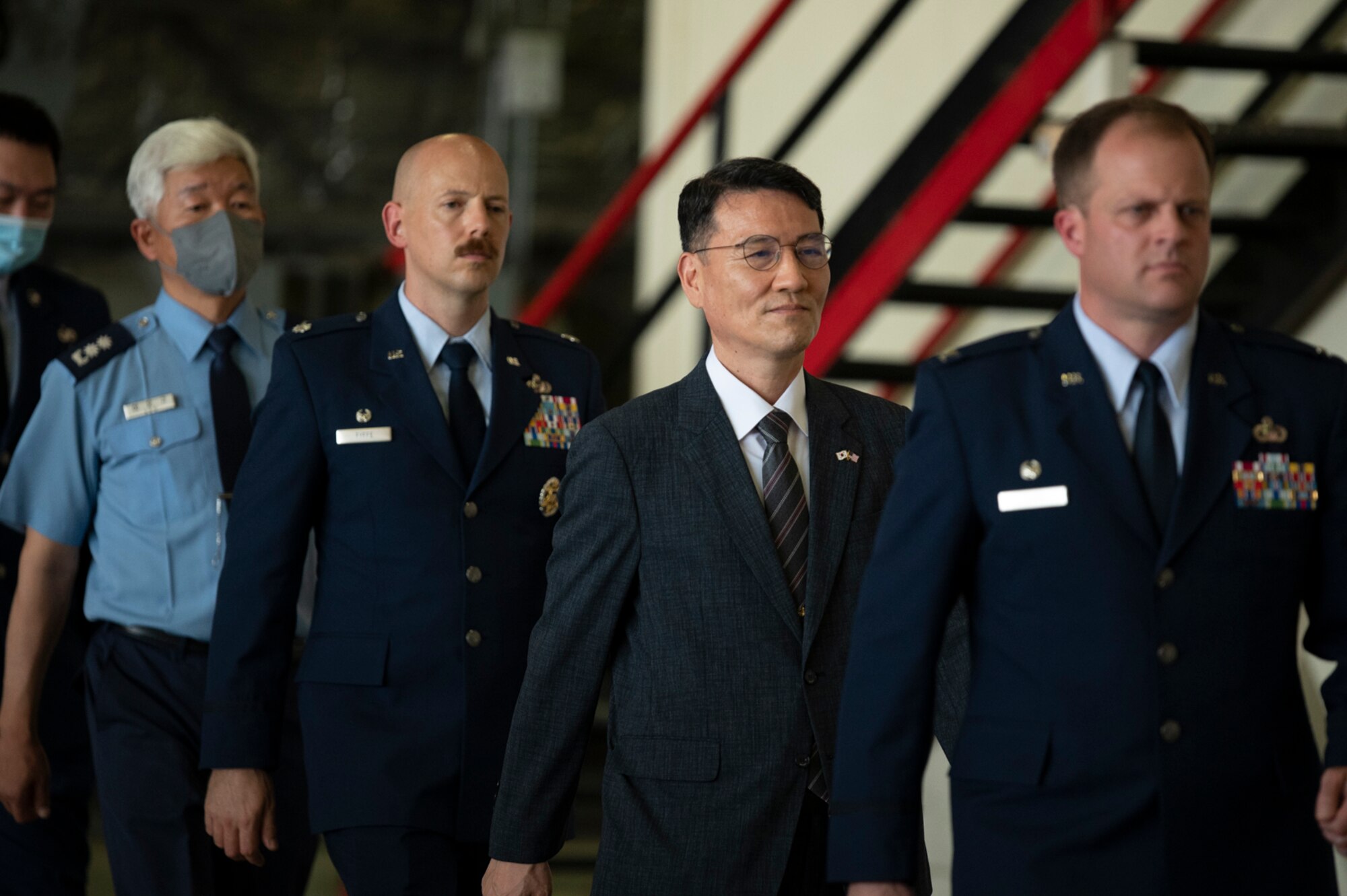 The official party of the 694th Intelligence Surveillance and Reconnaissance Group walks to their seats to commence the Meritorious Service Medal presentation at Osan Air Base, Republic of Korea, June 21, 2022.