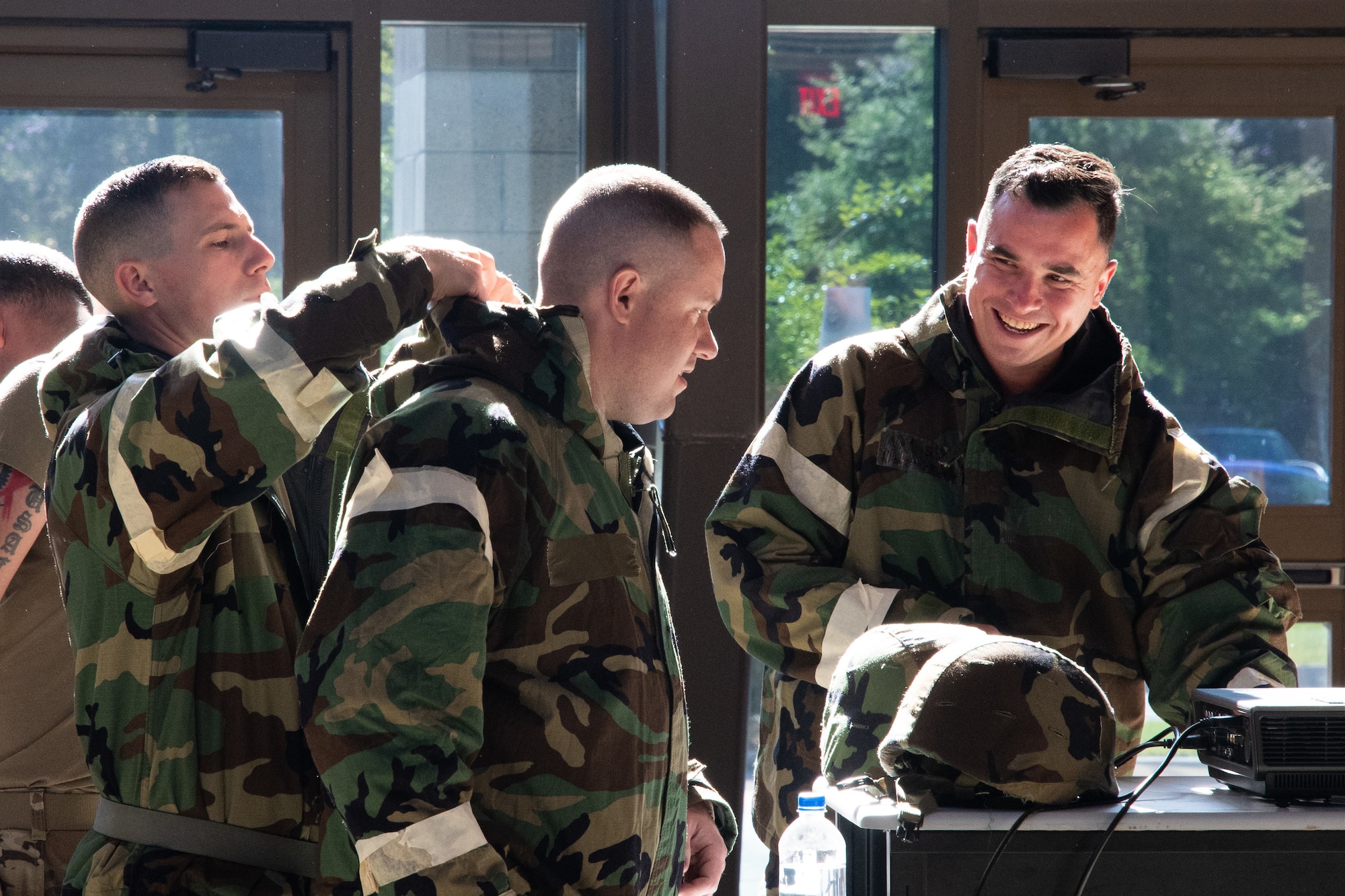 Members of the 221st Combat Communications Squadron prepare their protective gear during a brief on chemical warfare readiness during Exercise BUMBU 22 at Camp Shelby, Miss., June 4, 2022. BUMBU 22 brings five combat communications squadrons with the 254th Combat Communications Group from their home stations located across the nation together for a consolidated training exercise. (U.S. Air National Guard photo by Staff Sgt. Adrian Brakeley)