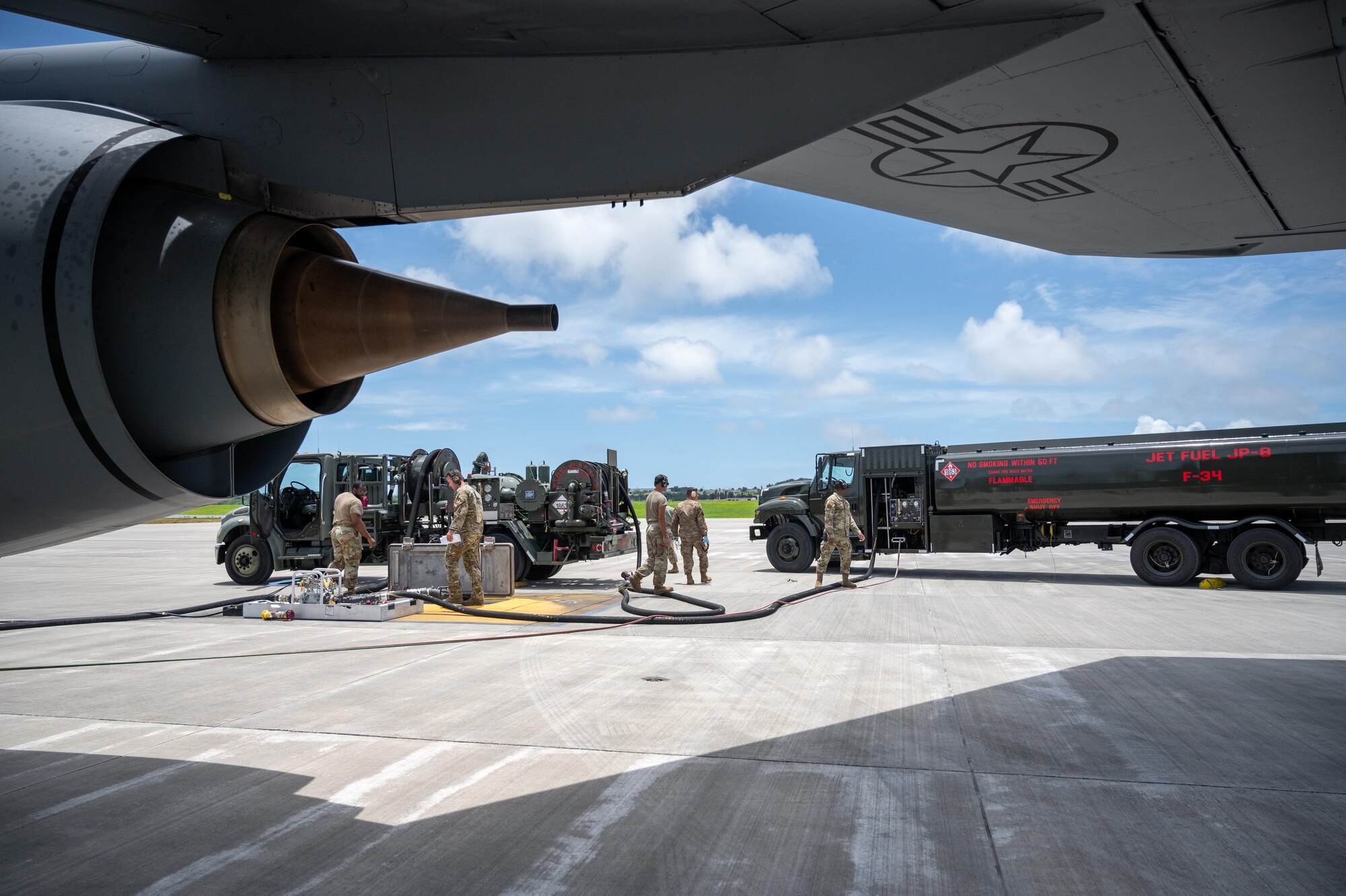 Airman standing in front of fuel trucks