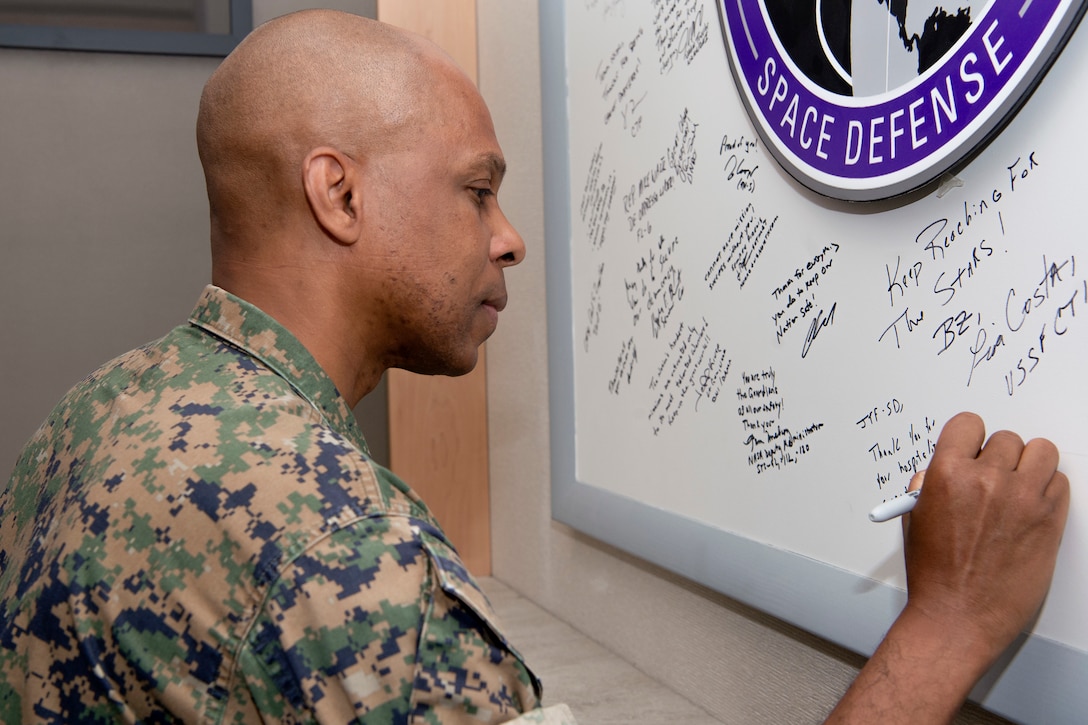 Marine in uniform signing board with marker