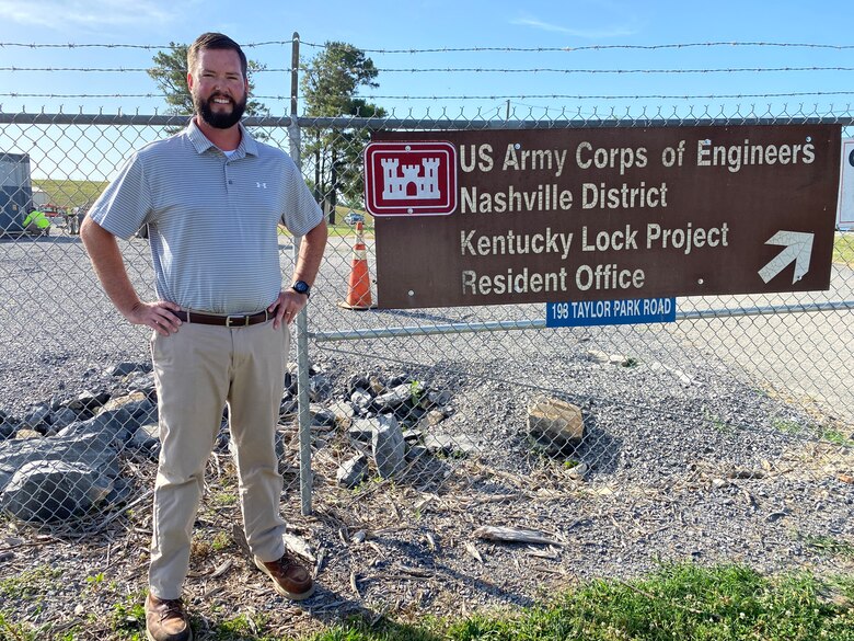 Justin Tabor, senior cost engineer, proudly stands outside the Kentucky Lock Addition Project resident engineer office. (USACE Photo by HEATHER KING.)