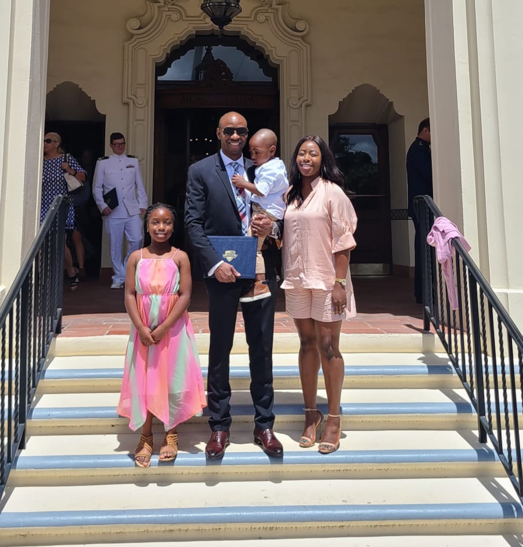 Ayodele Warburton stands with his wife and two children
