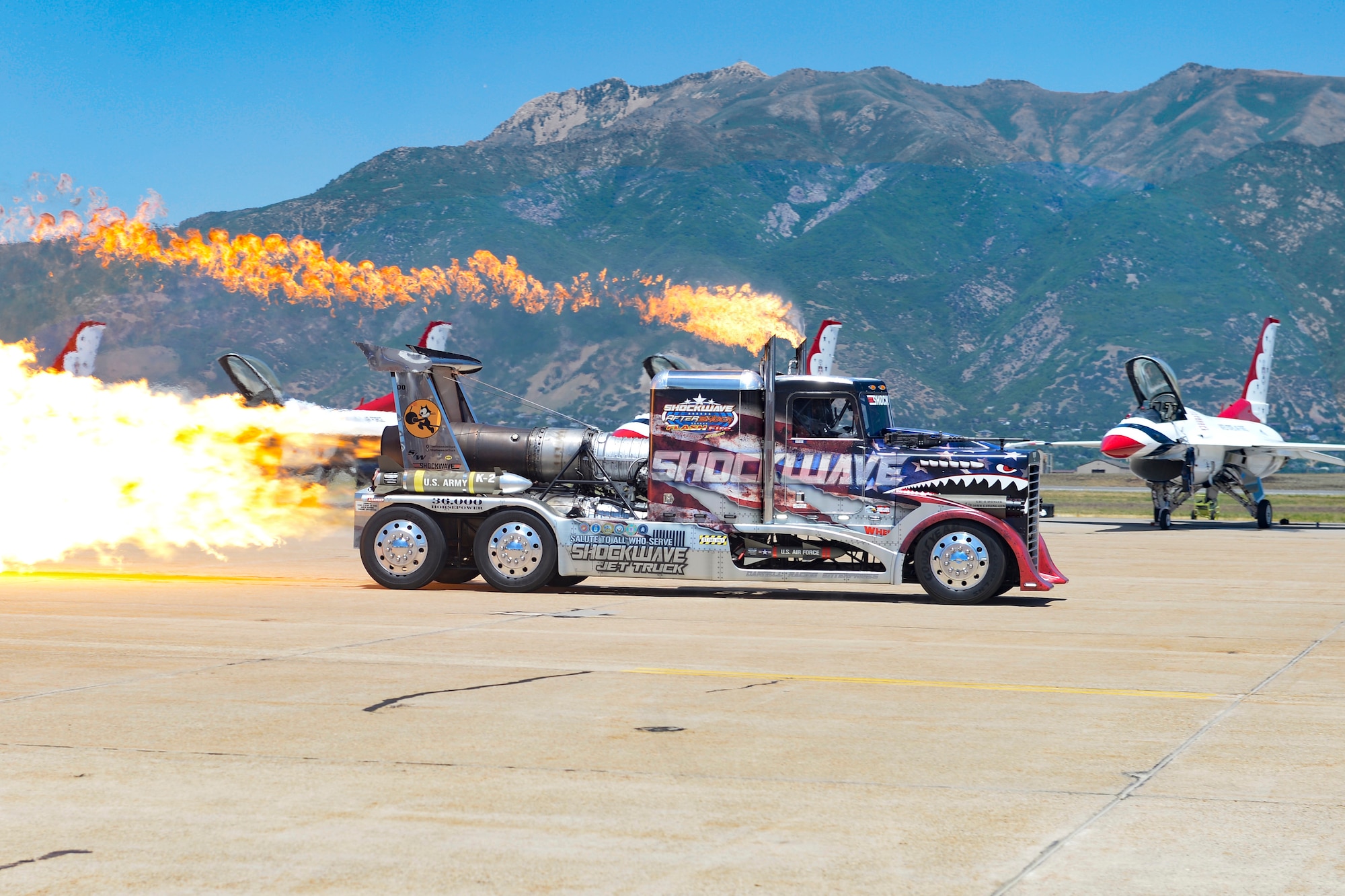 Flames spew out the back of a jet motor strapped to a semi-truck.