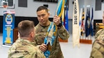 Army Lt. Col. Dennis Han hands the flag to DLA Indo-Pacific Military Deputy Commander Army Col. Brian Donahue