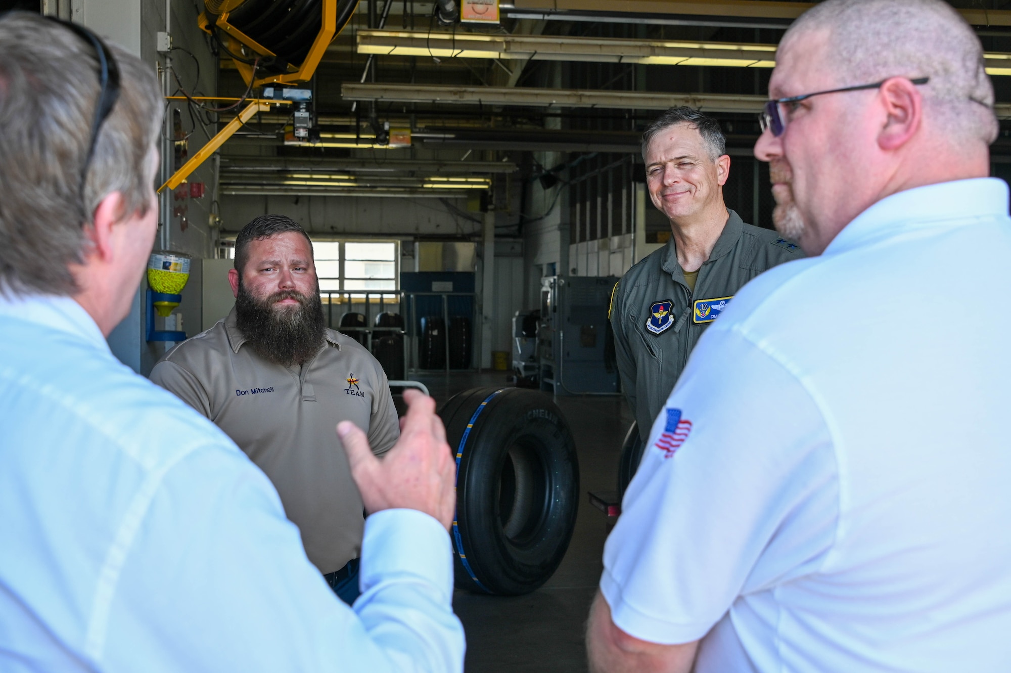 U.S. Air Force Maj. Gen. Craig D. Wills, 19th Air Force commander, takes a photo with 97th Maintenance Group members at Altus Air Force Base, Oklahoma, June 23, 2022. Wills visited the tire shop to learn about a new way of making KC-46 Pegasus tires. (U.S. Air Force photo by Senior Airman Kayla Christenson)
