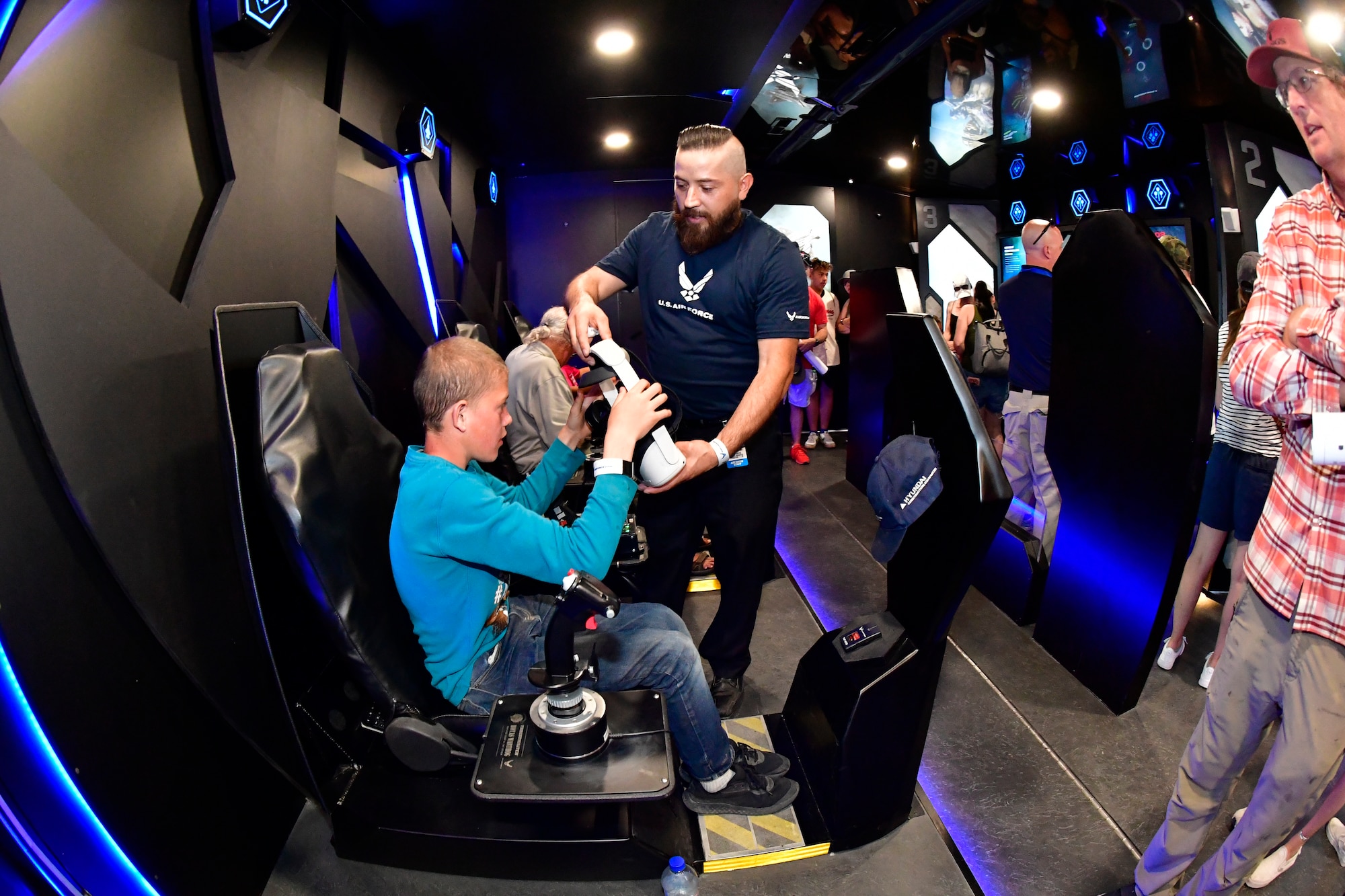 en Reese, Ascent Talent, assists Daniel Allred with the F-35 flight simulator Oculus headset inside an interactive exhibit.