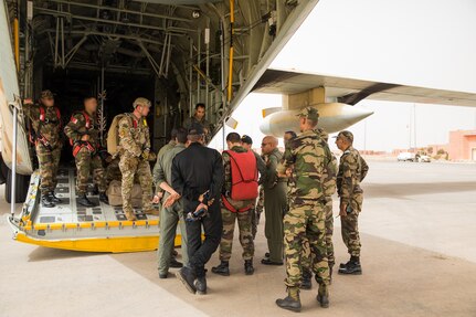 U.S. Army Soldiers assigned to the 19th Special Forces Group (Airborne), Utah Army National Guard, Royal Moroccan Army soldiers, and Tunisian Land Army paratroopers discuss the final details of how they will conduct the friendship airborne operation in Grier Labouihi, Morocco, during African Lion 22, June 19, 2022.