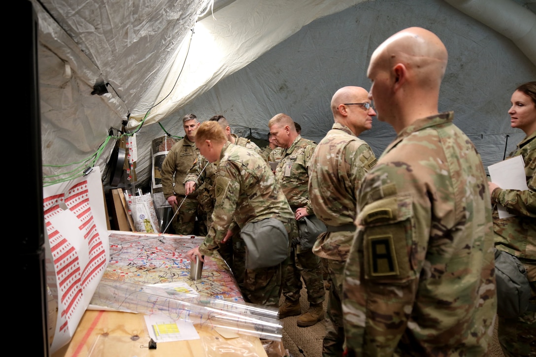 Observer coach/trainers assigned to the 157th Infantry Brigade, First Army Division East, observe 38th Infantry Division Soldiers updating the common operating picture during a command post exercise.
