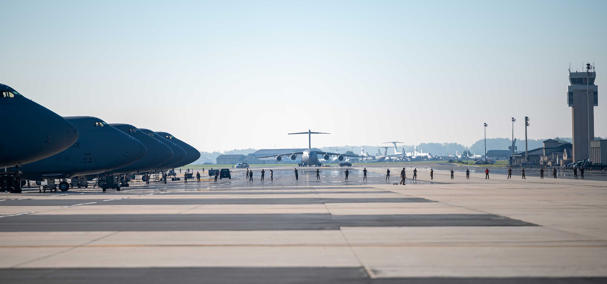 Airmen from the 436th Maintenance Squadron perform a foreign object debris walk on the flightline at Dover Air Force Base, Delaware, June 15, 2022. FOD walks are performed at least twice a day to ensure the flightline is clear of potential hazards. (U.S. Air Force photo by Senior Airman Faith Schaefer)