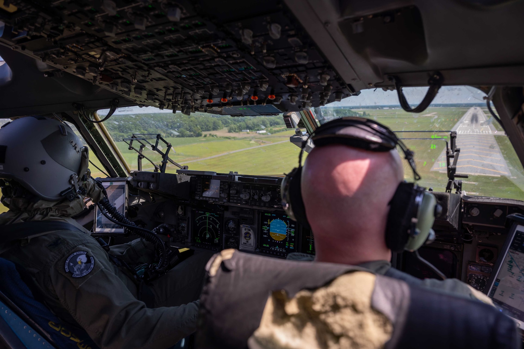 From right to left, Lt. Col. Steven Hawkins, 436th Operations Support Squadron commander, and Col. Scott Raleigh, 436th Operations Group commander, land a C-17 Globemaster III at Dover Air Force Base, Delaware, June 15, 2022. Raleigh landed the C-17 while wearing aircrew eye and respiratory protection system equipment, allowing for scenario-based preparation for possible real-world situations involving chemical, biological, radiological and nuclear environments. The local training flight included members from the 436th OG, 3rd Airlift Squadron and 436th OSS. (U.S. Air Force photo by Senior Airman Faith Schaefer)