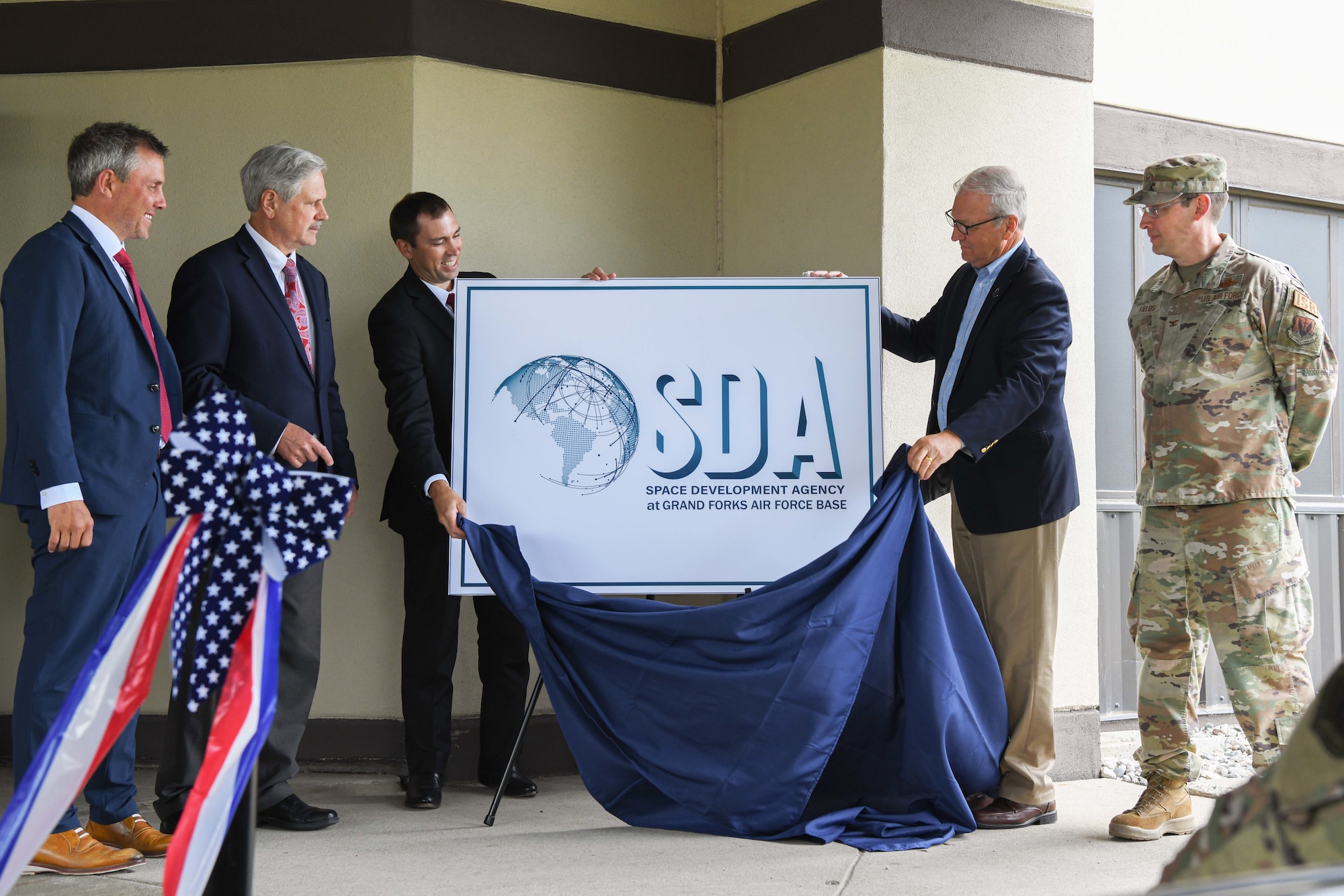 Derek Tournear, Space Development Agency director, and Sen. Kevin Cramer (R-ND), unveil the SDA sign during a Space Development Agency ribbon-cutting ceremony June 28, 2022, at Grand Forks Air Force Base, North Dakota. Grand Forks AFB was selected as the future home of Space Development Agency’s first ground operations and integration center, which will operate and control multiple-layer satellite operations for Tranche 1 of the National Defense Space Architecture. Space Development Agency is recognized as the Department of Defense’s constructive disruptor for space acquisition and will accelerate delivery of needed space-based capabilities to the joint warfighter to support terrestrial missions through development, fielding and operation of the National Defense Space Architecture. (U.S. Air Force photo by Senior Airman Ashley Richards)