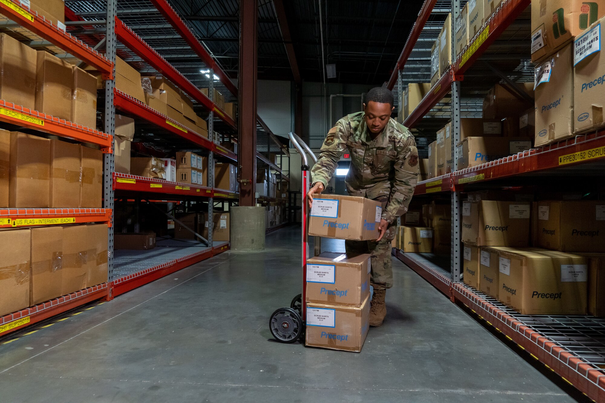 Senior Airman Osborne Barnard, Air Force Mortuary Affairs Operations departures specialist, assists with receiving logistical supplies in the AFMAO warehouse at Dover Air Force Base, Delaware, April 21, 2022. Barnard is a reservist deployed to AFMAO from the 512th Memorial Affairs Squadron. (U.S. Air Force photo by Jason Minto)