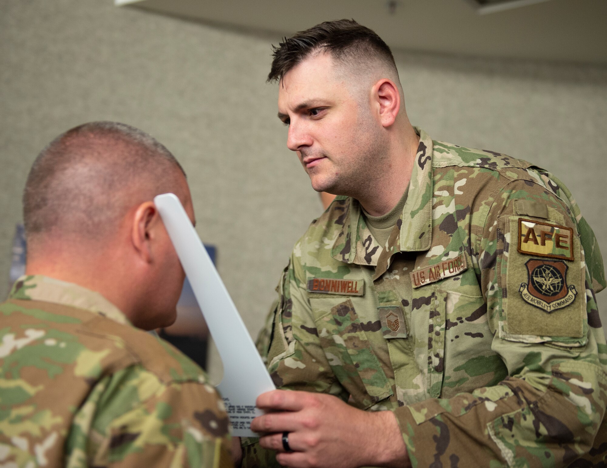 U.S. Air Force Master Sgt. Jacob Bonniwell, 133rd Aircrew Flight Equipment, sizes an Airman for an M69 Joint Service Aircrew Mask Strategic Aircraft (JSAM-SA) in St. Paul, Minn., June 9, 2022.