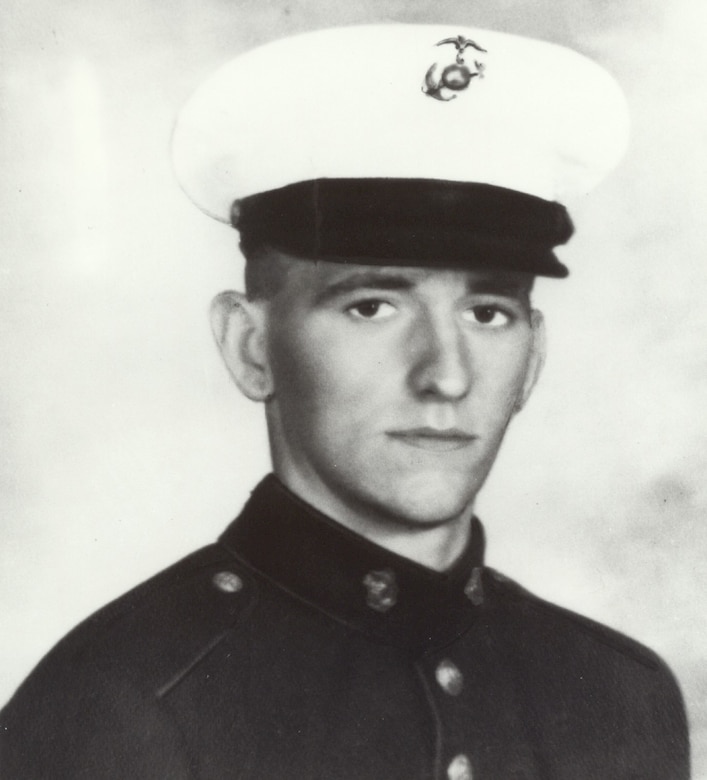 A man in uniform and dress cap poses for a photo.