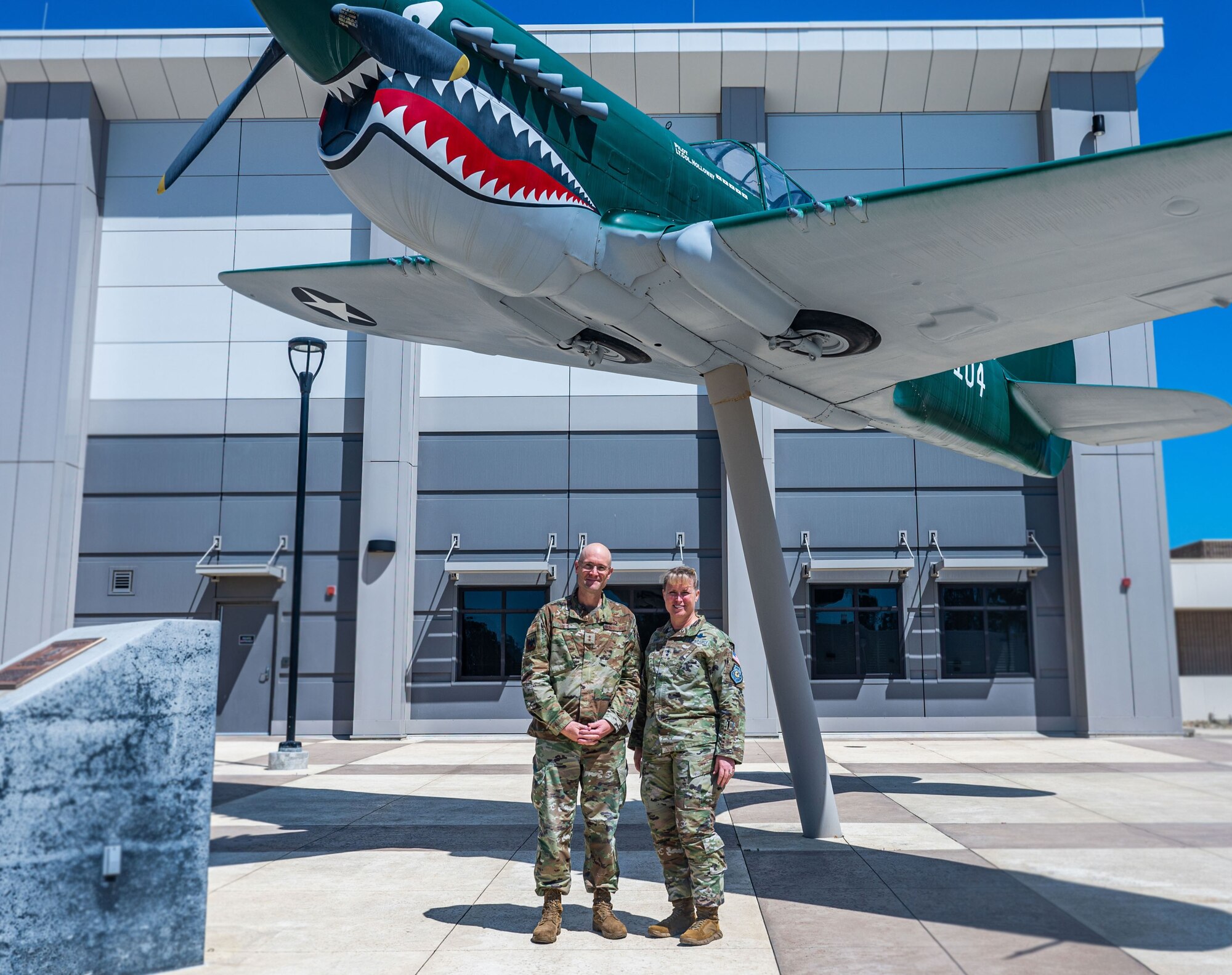 Maj. Gen. DeAnna Burt and Maj. Gen Greg White stand in front of a P-17 static display for a photo.