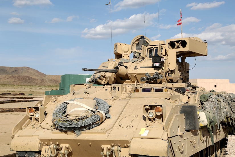 A light brown tank sits in a desert environment.