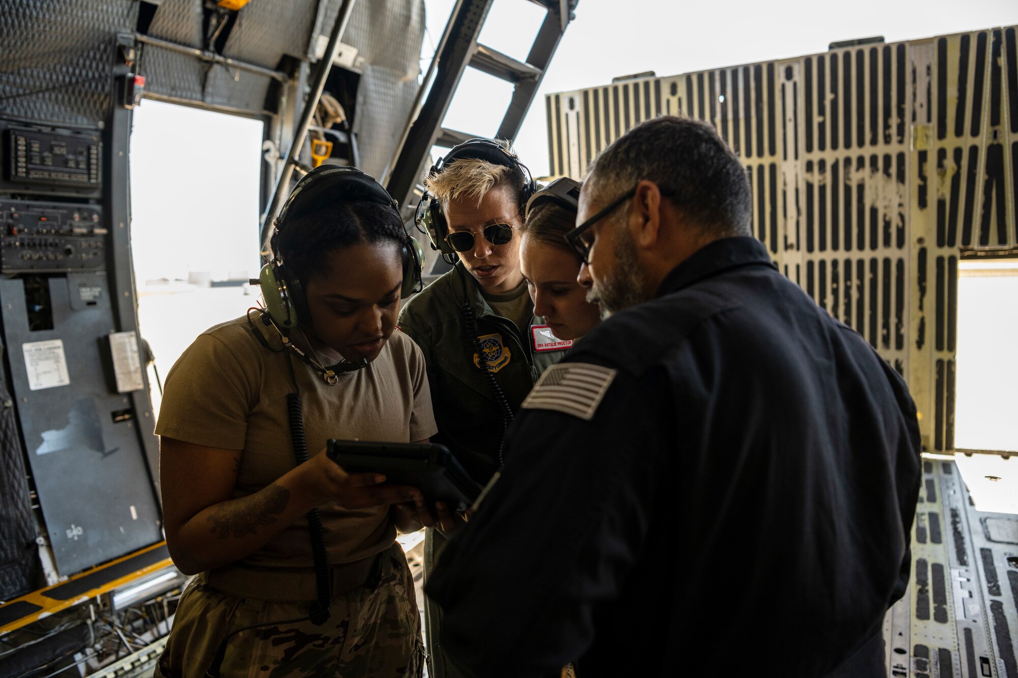 A group of aircrew look at procedures for a large military aircraft.