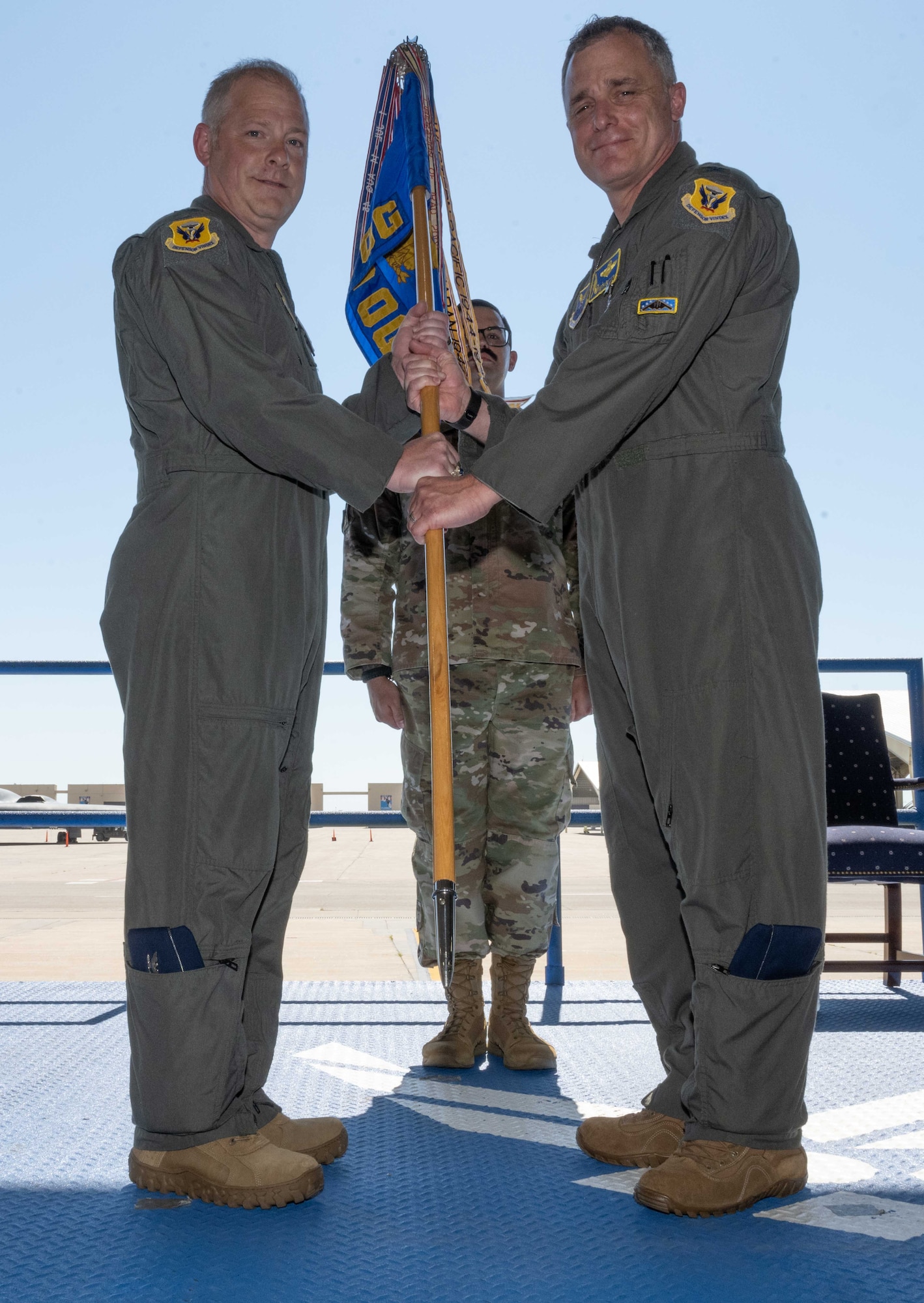 U.S. Air Force Col. Keith Butler relinquishes command of the 509th Operations Group and passes the ceremonial guidon to U.S. Air Force Col. Daniel Diehl, 509th Bomb Wing commander, at Whiteman Air Force Base, Missouri, June 29, 2022. The 509th OG is the flying component of the 509th Bomb Wing and is equipped with all 20 of the Air Force’s B-2 Spirit stealth bombers. (U.S. Air Force photo by Airman 1st Class Bryson Britt)