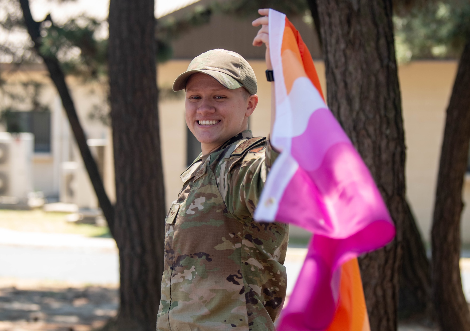 A military member poses with the lesbian pride flag.