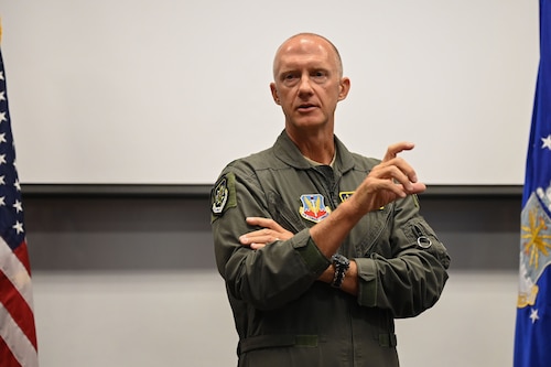 photo USAF Airman standing in front a group of seated individuals