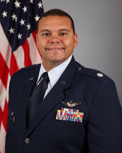 photo of US Air Force Airman standing in front of US flag