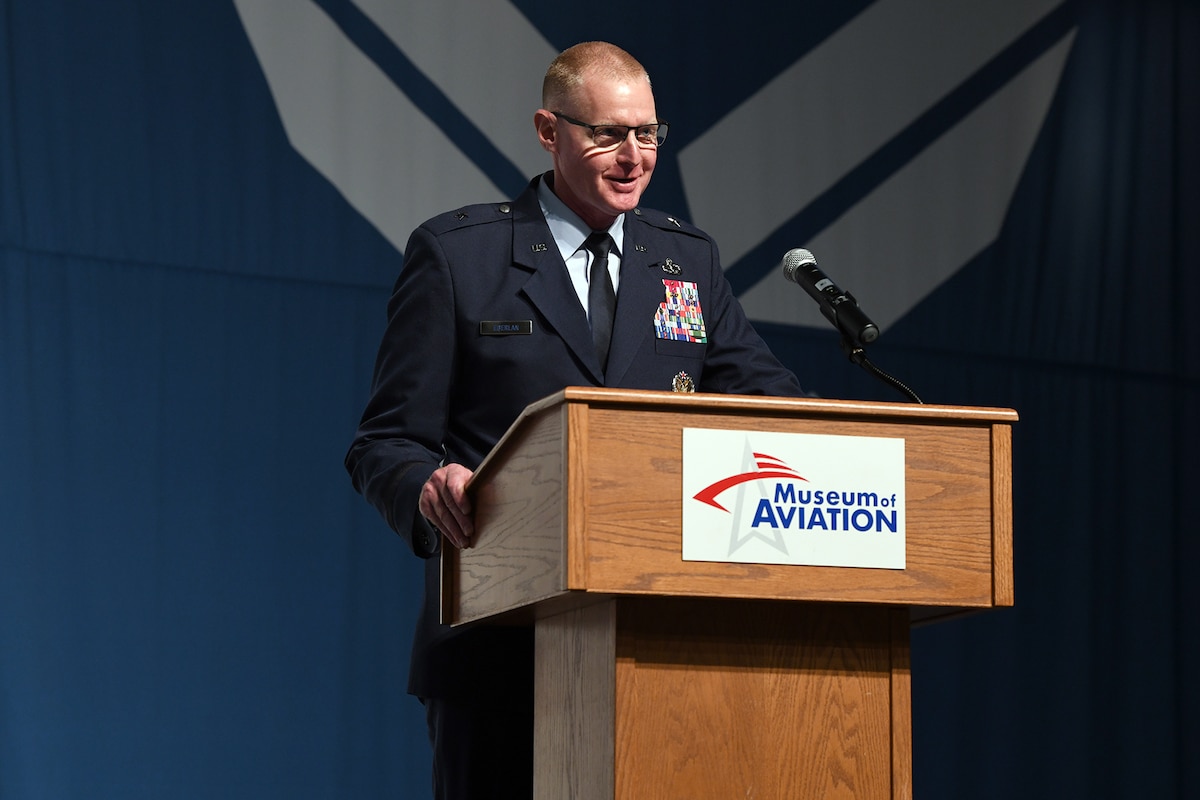 Photo shows man speaking at a podium.
