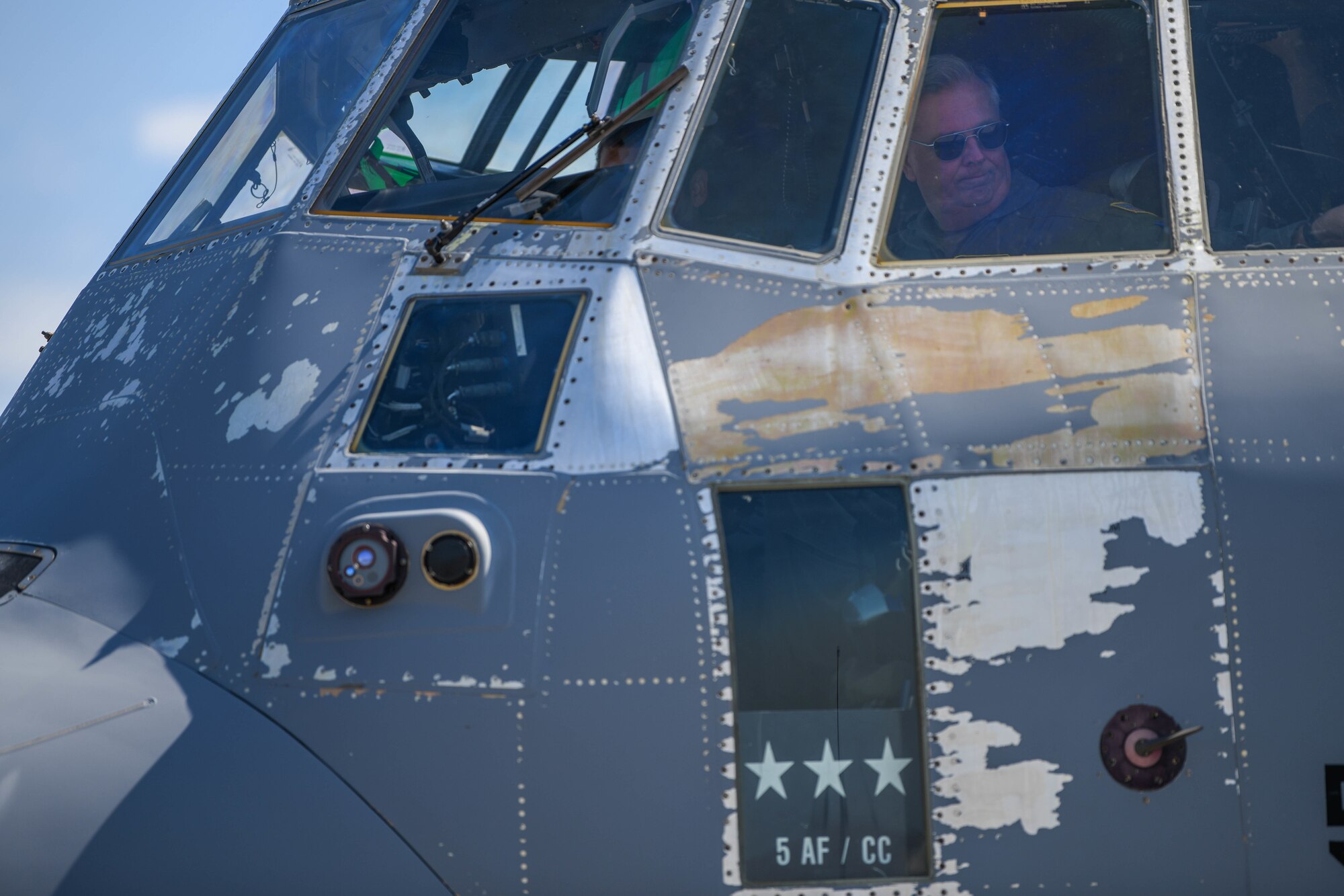 Commander looks out a window of a C-130J Super Hercules