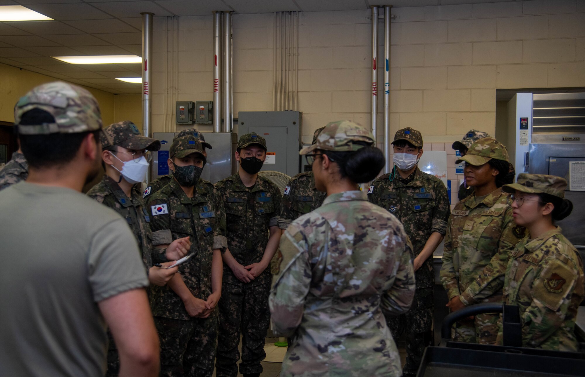 Korean and U.S. service members standing in a circle talking to each other