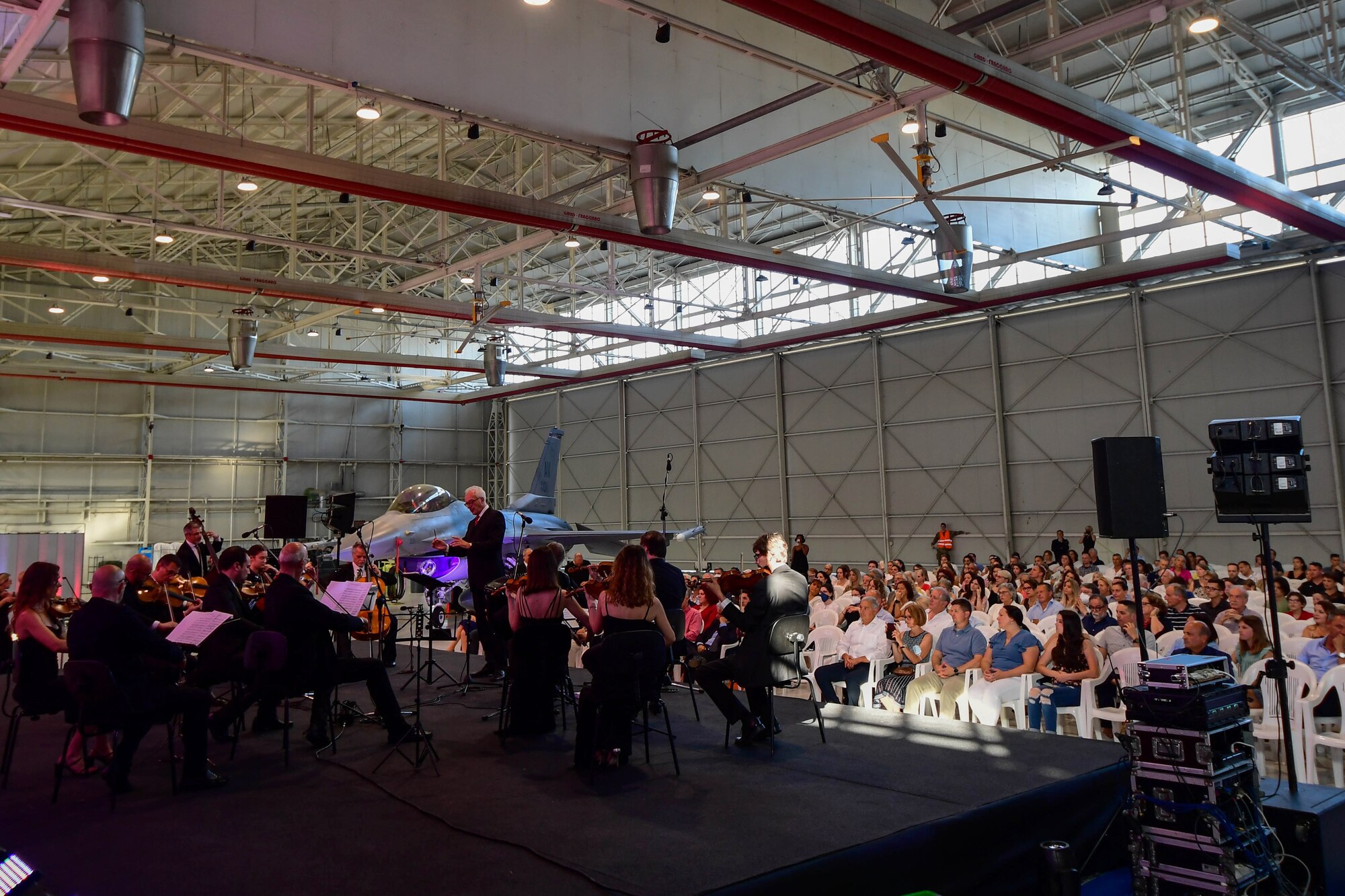U.S. Air Force Brig. Gen. Jason Bailey, 31st Fighter Wing Commander, speaks at the Chamber Orchestra “Nuova Orchestra da Camera Ferruccio Busoni” concert at Aviano Air Base, Italy, June 29, 2022. They were directed by Maestro Massimo Belli and performed “Melodies of the Century”. The goal of these events is to bring two nations together through music, international language and a sense of community. (U.S. Air Force photo by Senior Airman Noah Sudolcan)