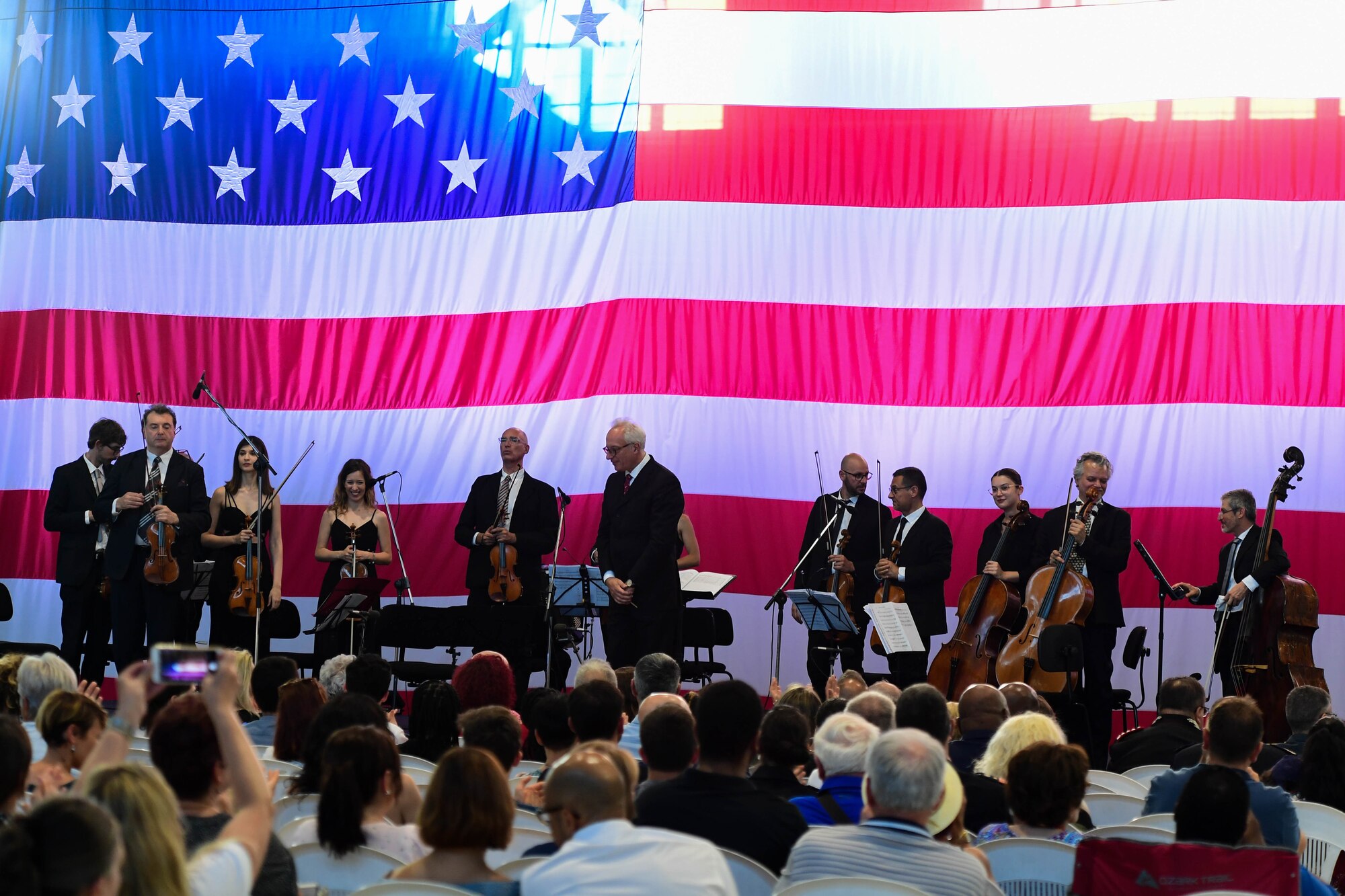 U.S. Air Force Brig. Gen. Jason Bailey, 31st Fighter Wing Commander, speaks at the Chamber Orchestra “Nuova Orchestra da Camera Ferruccio Busoni” concert at Aviano Air Base, Italy, June 29, 2022. They were directed by Maestro Massimo Belli and performed “Melodies of the Century”. The goal of these events is to bring two nations together through music, international language and a sense of community. (U.S. Air Force photo by Senior Airman Noah Sudolcan)