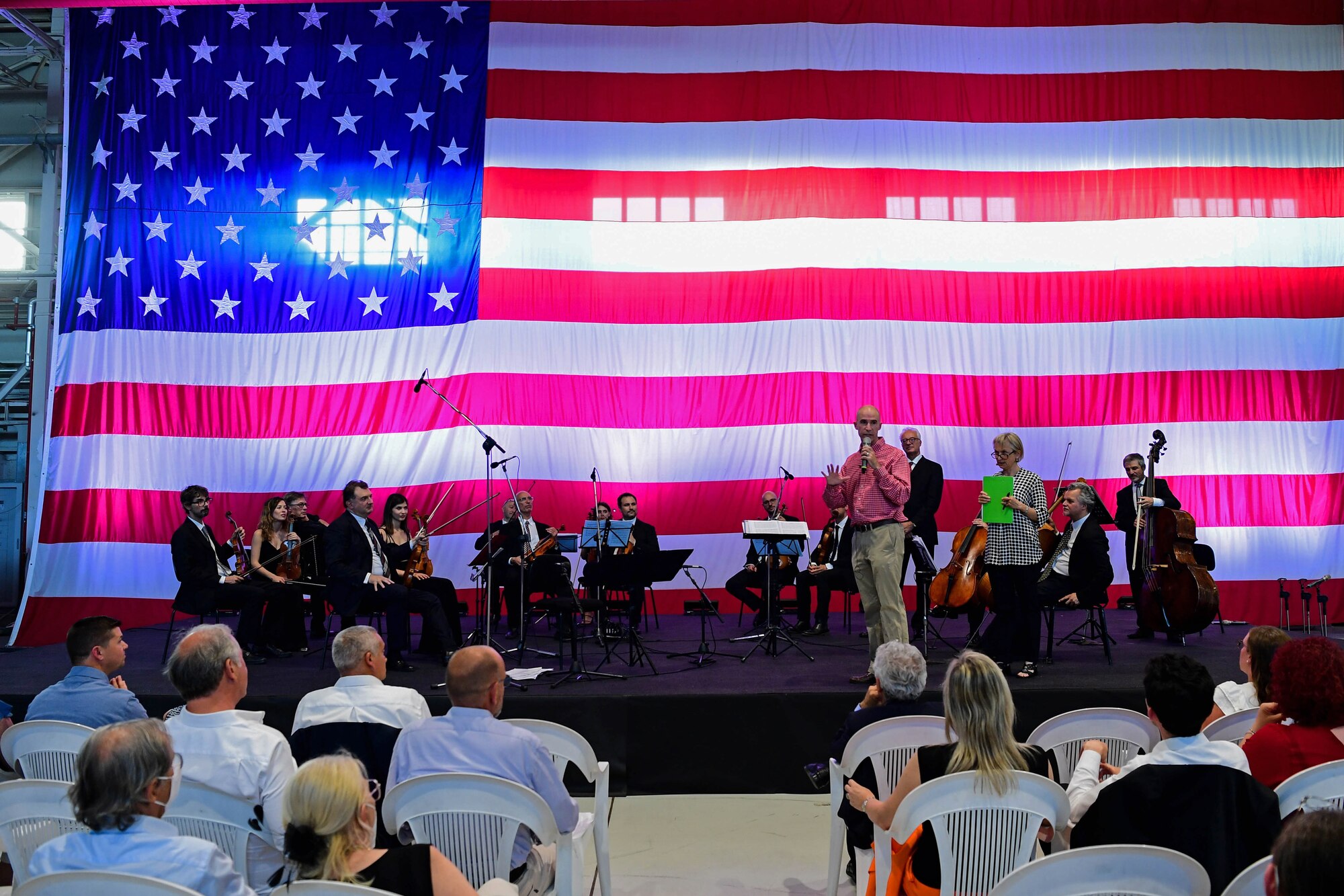 U.S. Air Force Brig. Gen. Jason Bailey, 31st Fighter Wing Commander, speaks at the Chamber Orchestra “Nuova Orchestra da Camera Ferruccio Busoni” concert at Aviano Air Base, Italy, June 29, 2022. They were directed by Maestro Massimo Belli and performed “Melodies of the Century”. The goal of these events is to bring two nations together through music, international language and a sense of community. (U.S. Air Force photo by Senior Airman Noah Sudolcan)