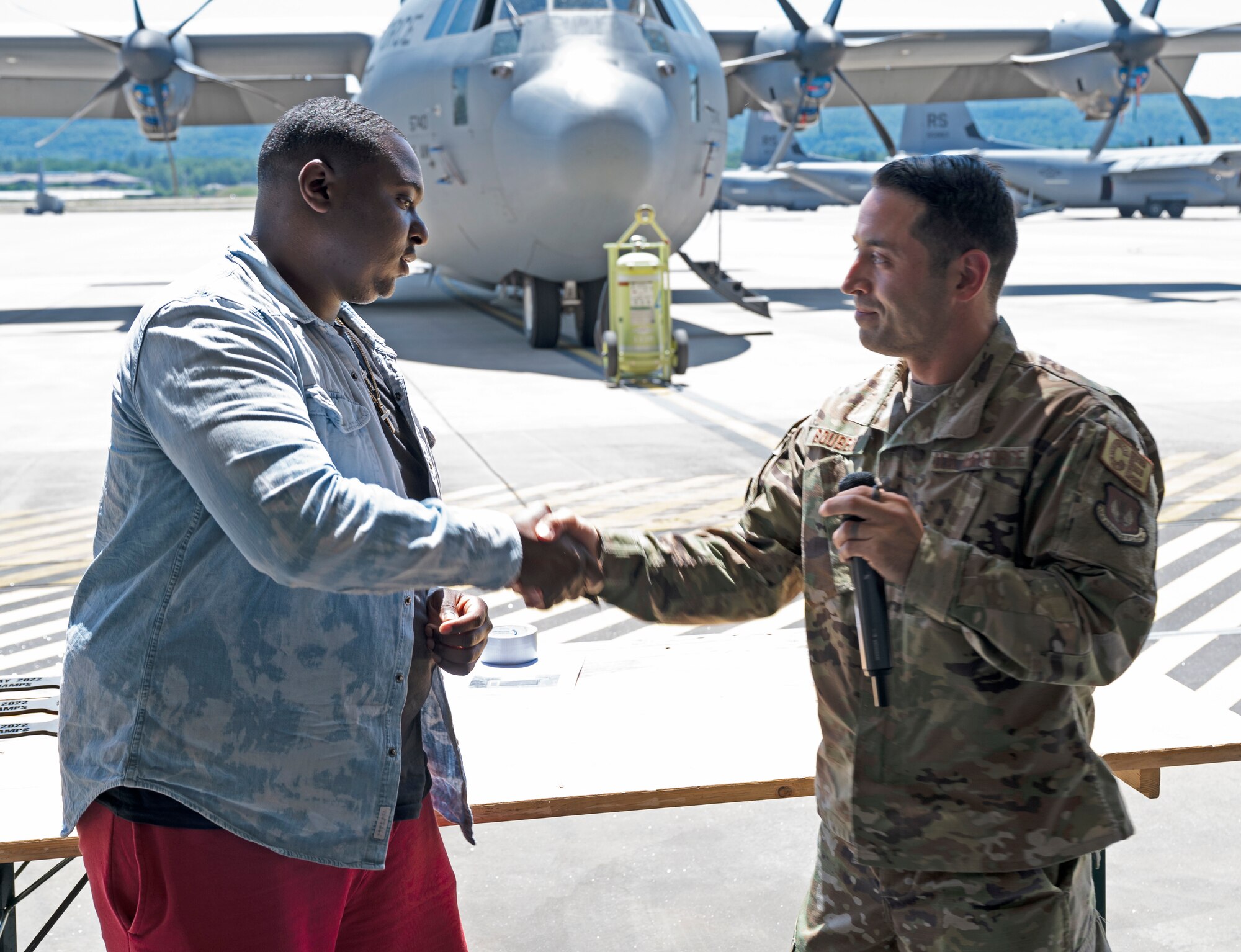U.S. Air Force Col. Denny Davis, 86th Airlift Wing vice commander, gives a coin to U.S. Air Force Staff Sgt. Javion Hoyle, 86th Maintenance Squadron aircraft fuels systems craftsmen, for being awarded Airlifter of the Month at Ramstein Air Base, Germany,  June 16, 2022,. Hoyle earned the title of Airlifter of the Month because of his work ethic, can-do attitude and ability to be flexible when his team needs help. (U.S. Air Force photo by Senior Airman Thomas Karol)