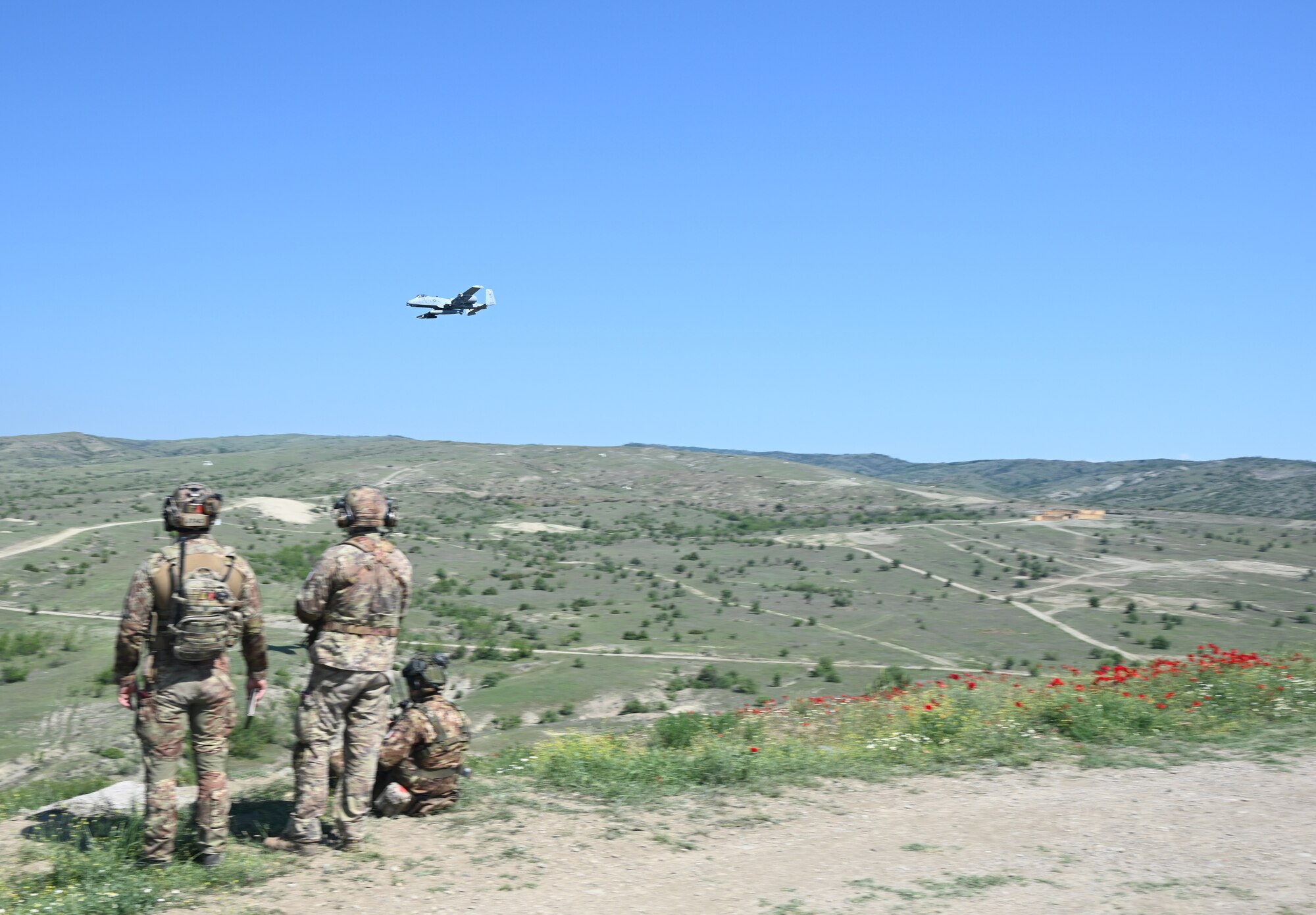 Three joint terminal attack controllers assigned to the Folgore Army Paratroopers of the Italian Army, observe an A-10C Thunderbolt II aircraft assigned to the 104th Fighter Squadron, Maryland Air National Guard, during a Swift Response 22 exercise at the Krivolak Military Training Center in Negotino, North Macedonia, May 11, 2022.