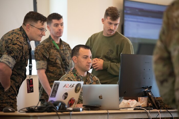Master Sgt. Mike McAllister, cyberspace operations chief, Marine Innovation Unit ,discusses his network hacking plans with red team 1 during Cyber Yankee 22 on Camp Nett, Connecticut , June 15, 2022. During Cyber Yankee service members are divided up into red teams and blue teams. The Reserve Marines from MIU participated in Cyber Yankee for the first time and plan to continue to support similar exercises to bring extra subject matter expertise in an effort to address advanced technology challenges facing the Department of Defense and the United States.