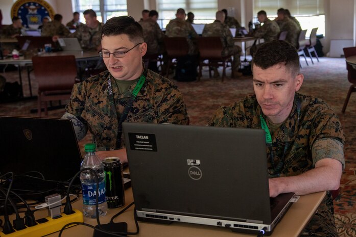 Sgt. Ian McConnell a cyber warfare operator for Defensive Cyberspace Operations-Internal Defensive Measures, 8th Communication Battalion, and Sgt. John Kinsey a  cyber warfare operator for Marine Special Operations Command 3-9 Cyber operations team  discusses their network hacking plans during Cyber Yankee 22 on Camp Nett, Conn., June 13, 2022. During Cyber Yankee service members are divided up into red teams and blue teams. All participating Marines are part of the red team. The red team acts as an attacking force while the blue team tries to defend their network.