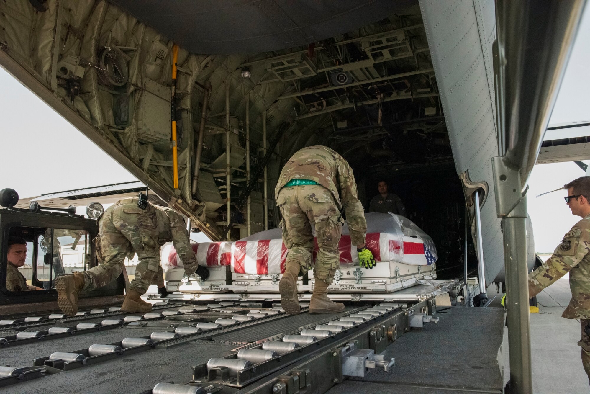 U.S. Air Force Airmen secure nine caskets containing remains of unidentified service members in a C-130 Hercules at Aviano Air Base, June 27, 2022