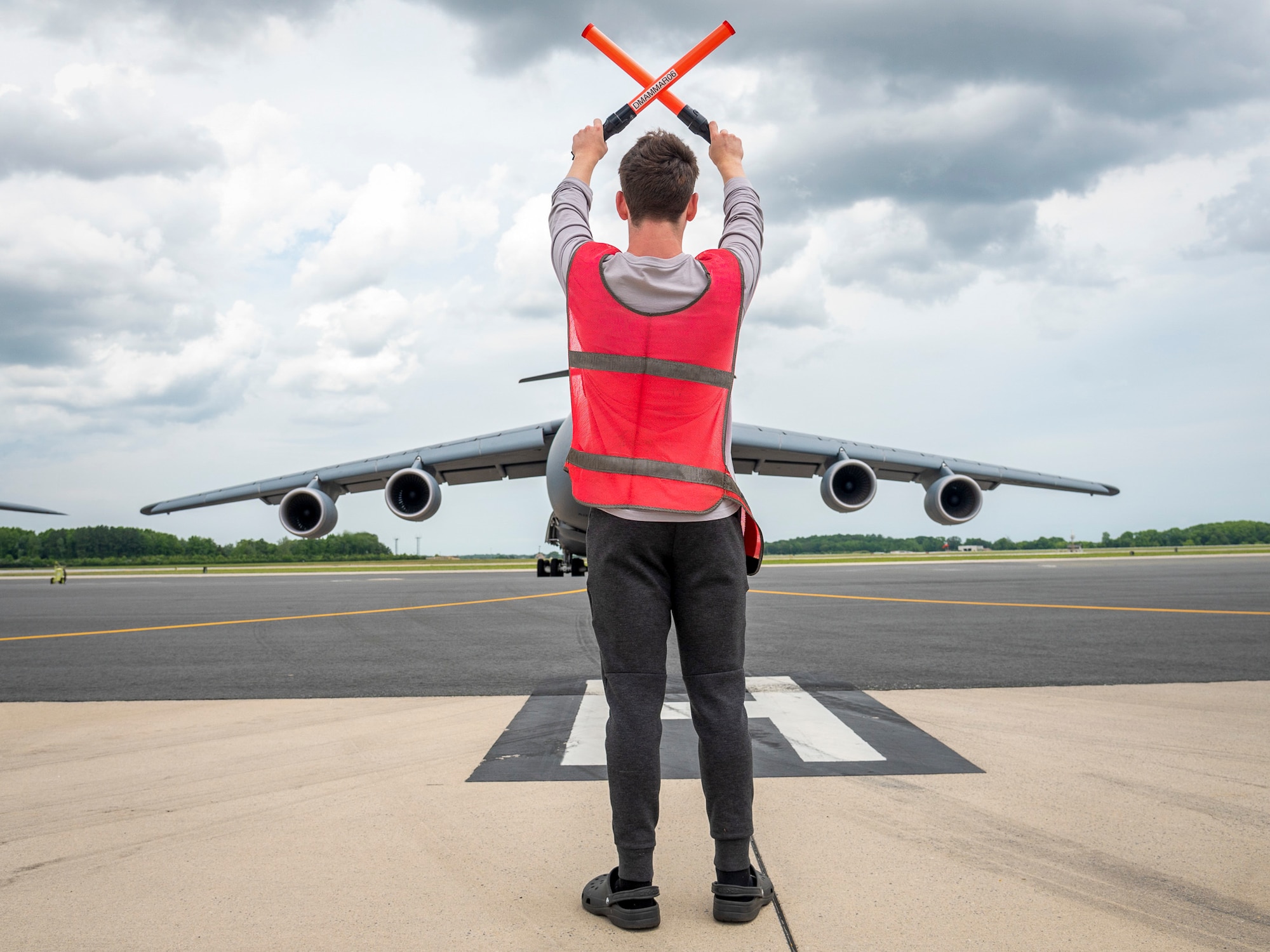 Weston Werner, son of U.S. Air Force Lt. Col. Anita West-Werner, 512th Operations Group, Dover Air Force Base, Delaware, brings a C-5M Super Galaxy to a stop while marshalling June 7, 2022. West-Werner flew her final flight after 26 years with the 512th AW. West-Werner's next assignment is at the Pentagon in Arlington, Virginia, where she'll be the Individual Mobilization Augmentee to the Director of the Air Force Crisis Action Team. (U.S. Air Force photo by Mauricio Campino)