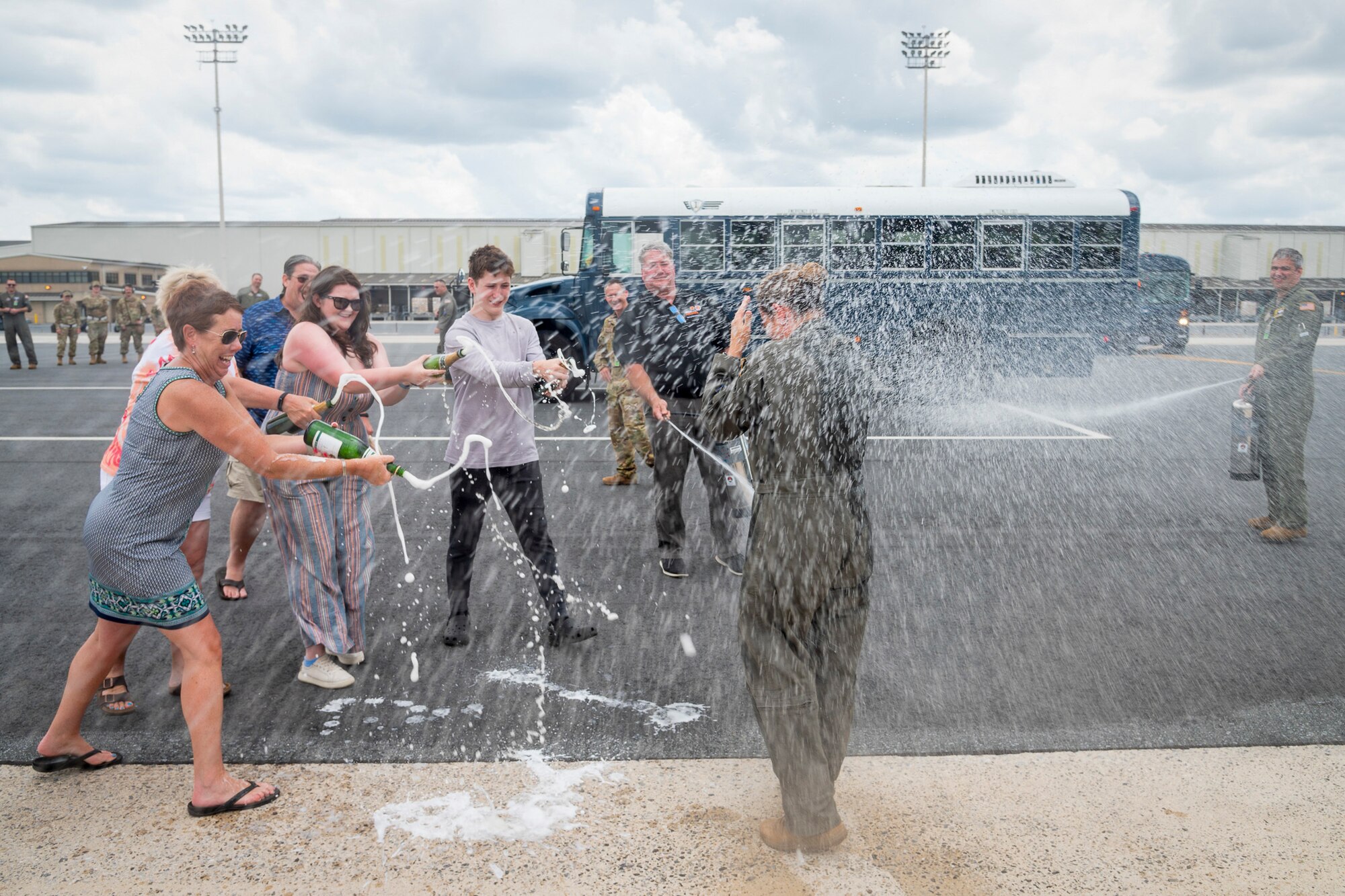 U.S. Air Force Lt. Col. Anita West-Werner, 512th Operations Group, Dover Air Force Base, Delaware, gets drenched by family and friends after her final flight June 7, 2022. A final flight, also known as fini-flight, is a tradition for pilots and some aircrew members who are retiring or moving to another base. West-Werner flew her final flight after 26 years with the 512th AW. (U.S. Air Force photo by Mauricio Campino)