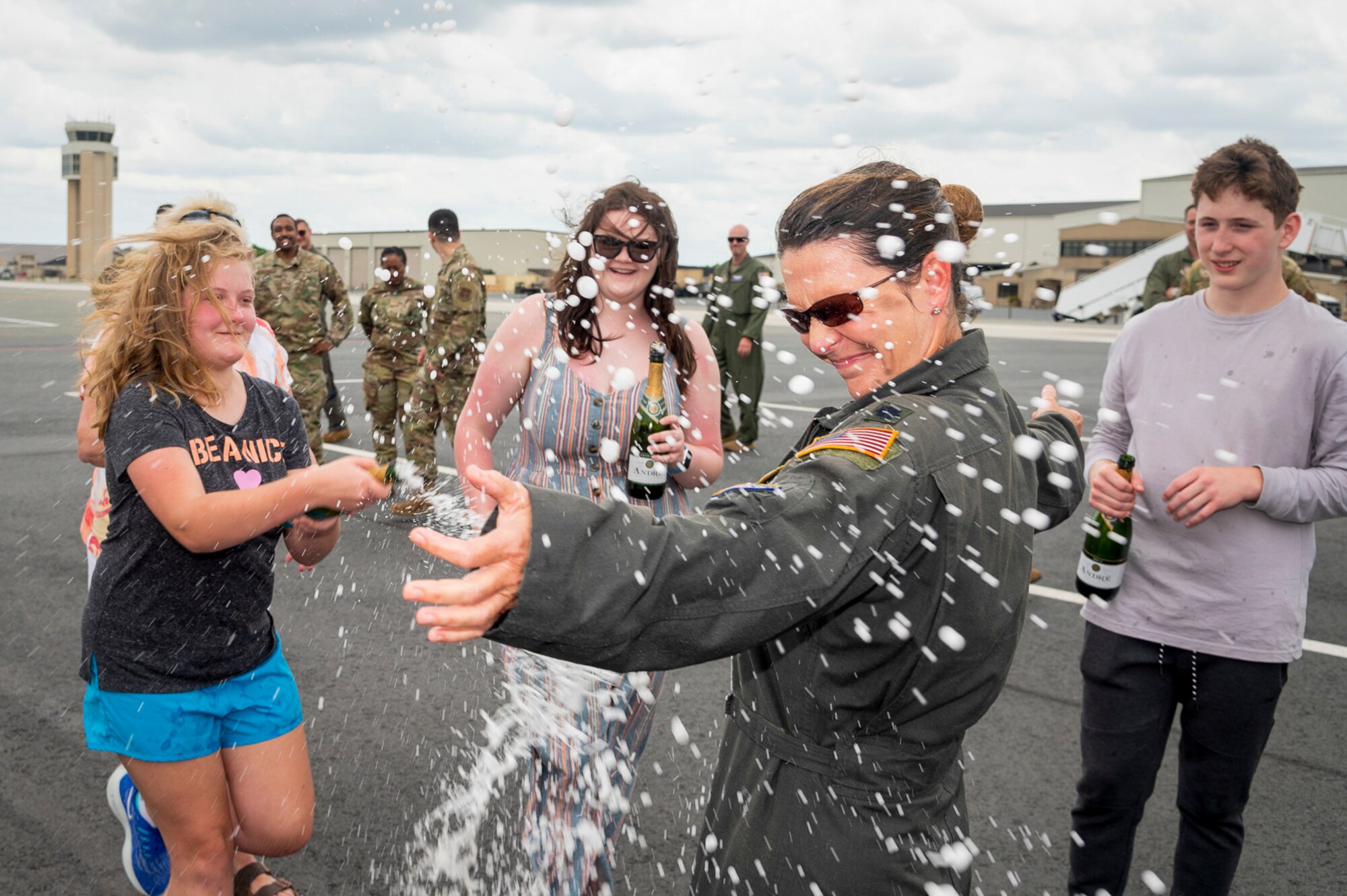 U.S. Air Force Lt. Col. Anita West-Werner, 512th Operations Group, Dover Air Force Base, Delaware, gets drenched by family and friends after her final flight June 7, 2022. A final flight, also known as fini-flight, is a tradition for pilots and some aircrew members who are retiring or moving to another base. West-Werner flew her final flight after 26 years with the 512th AW. (U.S. Air Force photo by Mauricio Campino)