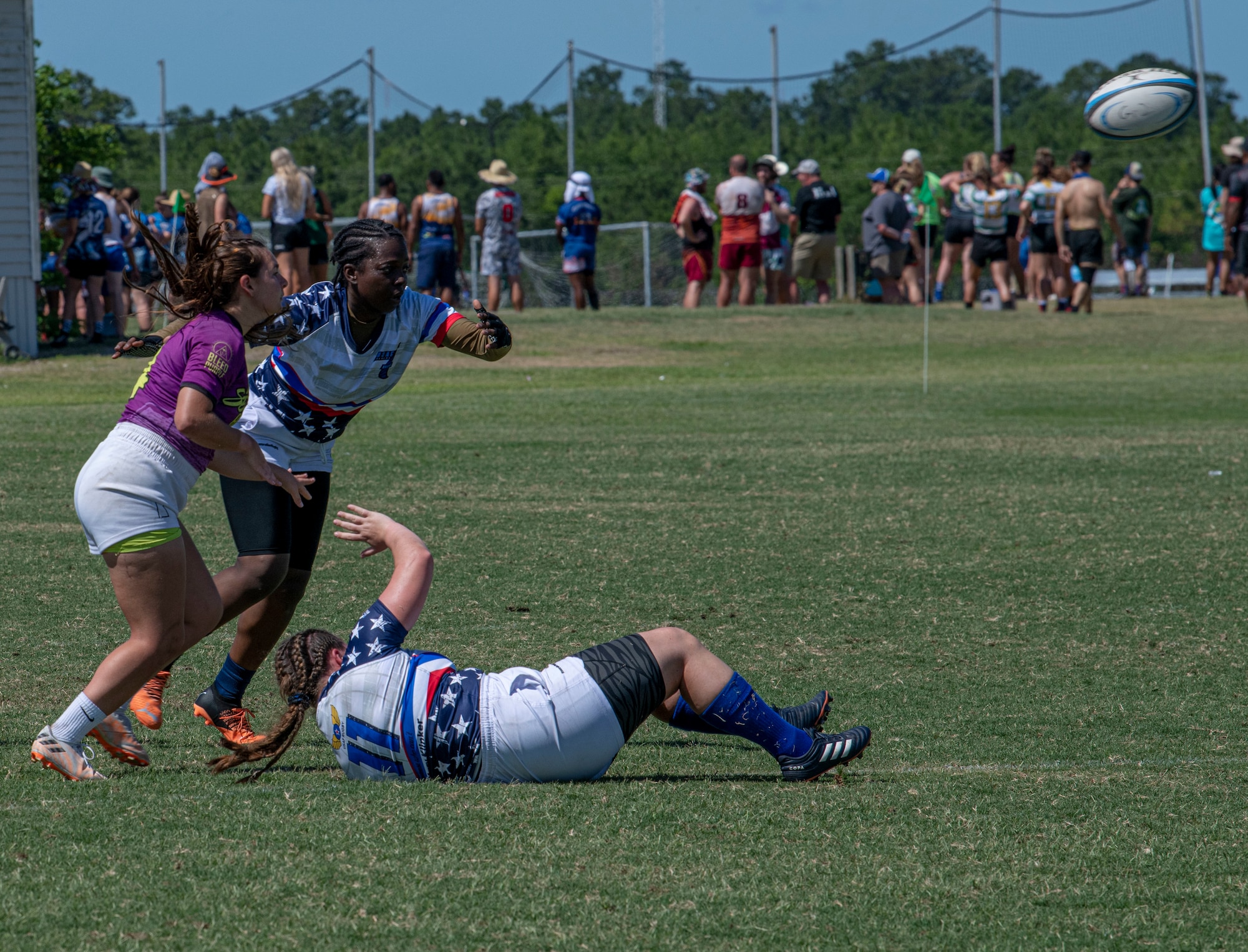 Members of the Department of Air Force Women's Rugby Team pass the ball backwards to another team member during a game against the Northern Virginia Rugby Team after competing in the Annual Armed Forces Women’s Rugby Championship in Wilmington, North Carolina, June 26, 2022. Players use skills such as sprinting, side-stepping and tackling to out-maneuver their competition. (U.S. Air Force photo by Airman 1st Class Sabrina Fuller)