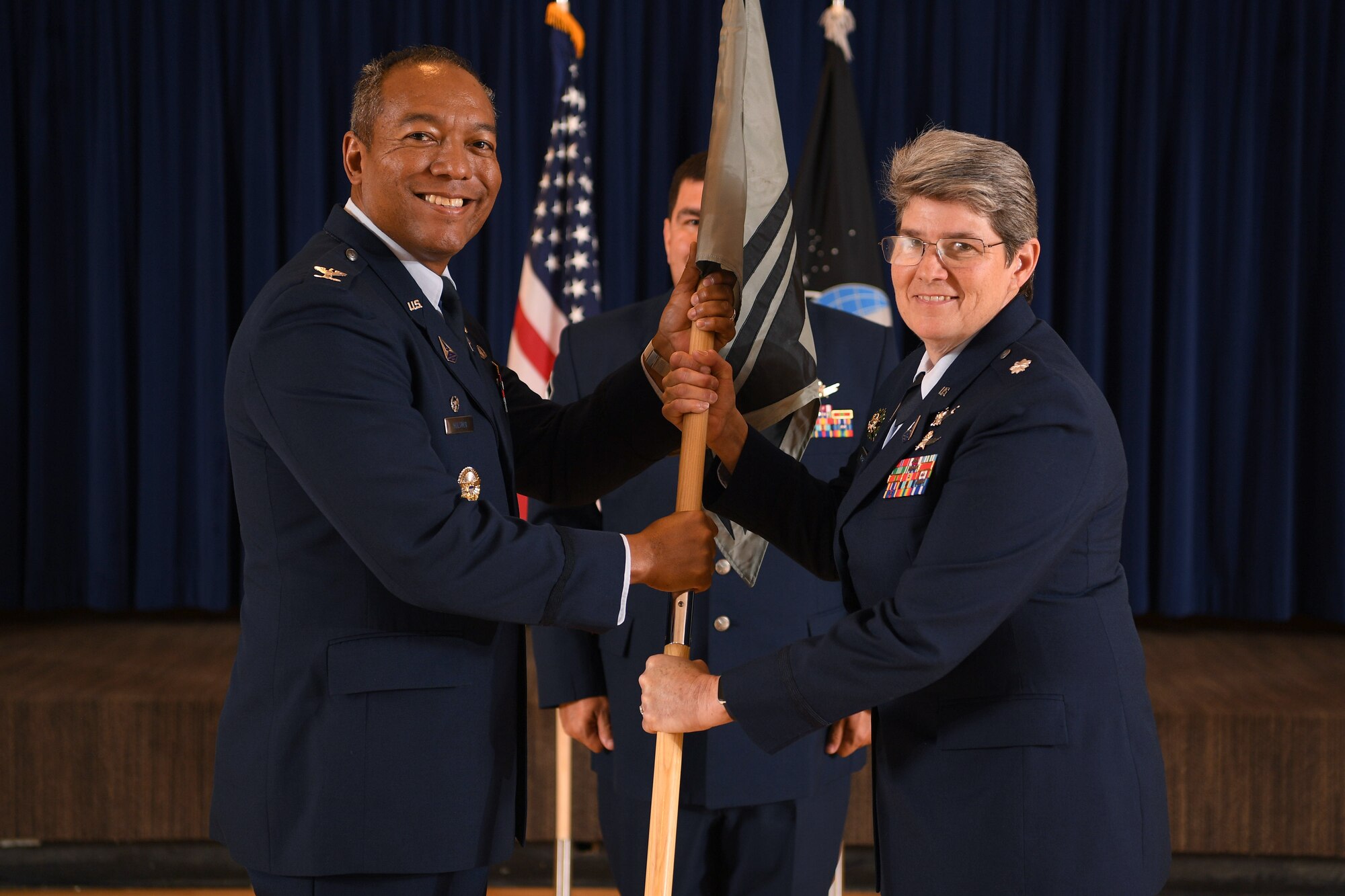 two people passing guidon