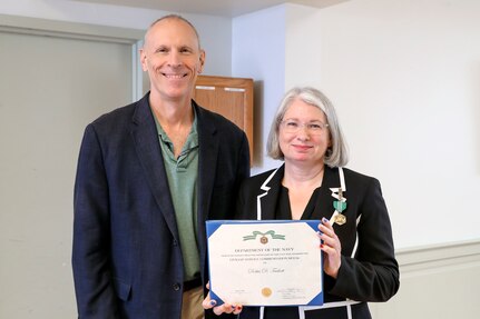 NSWC IHD Technical Director Ashley Johnson presents the command’s former Corporate Operations Deputy Head Dottie Tackett with the DON Civilian Service Commendation Medal, June 23. (U.S. Navy photo by Matthew Poynor)