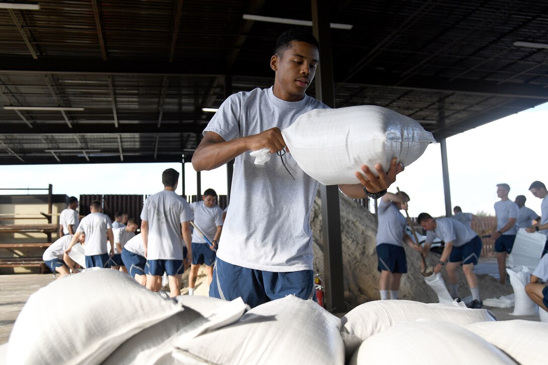 Airmen stacks sandbags.