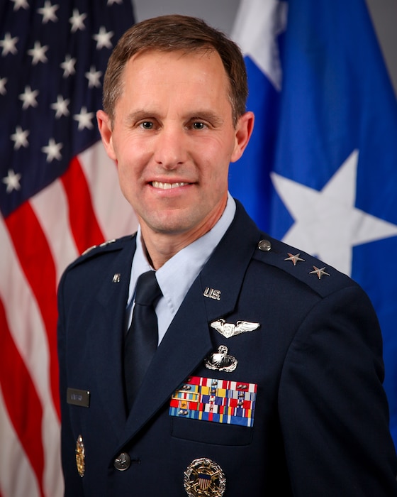 Airmen in front of flags